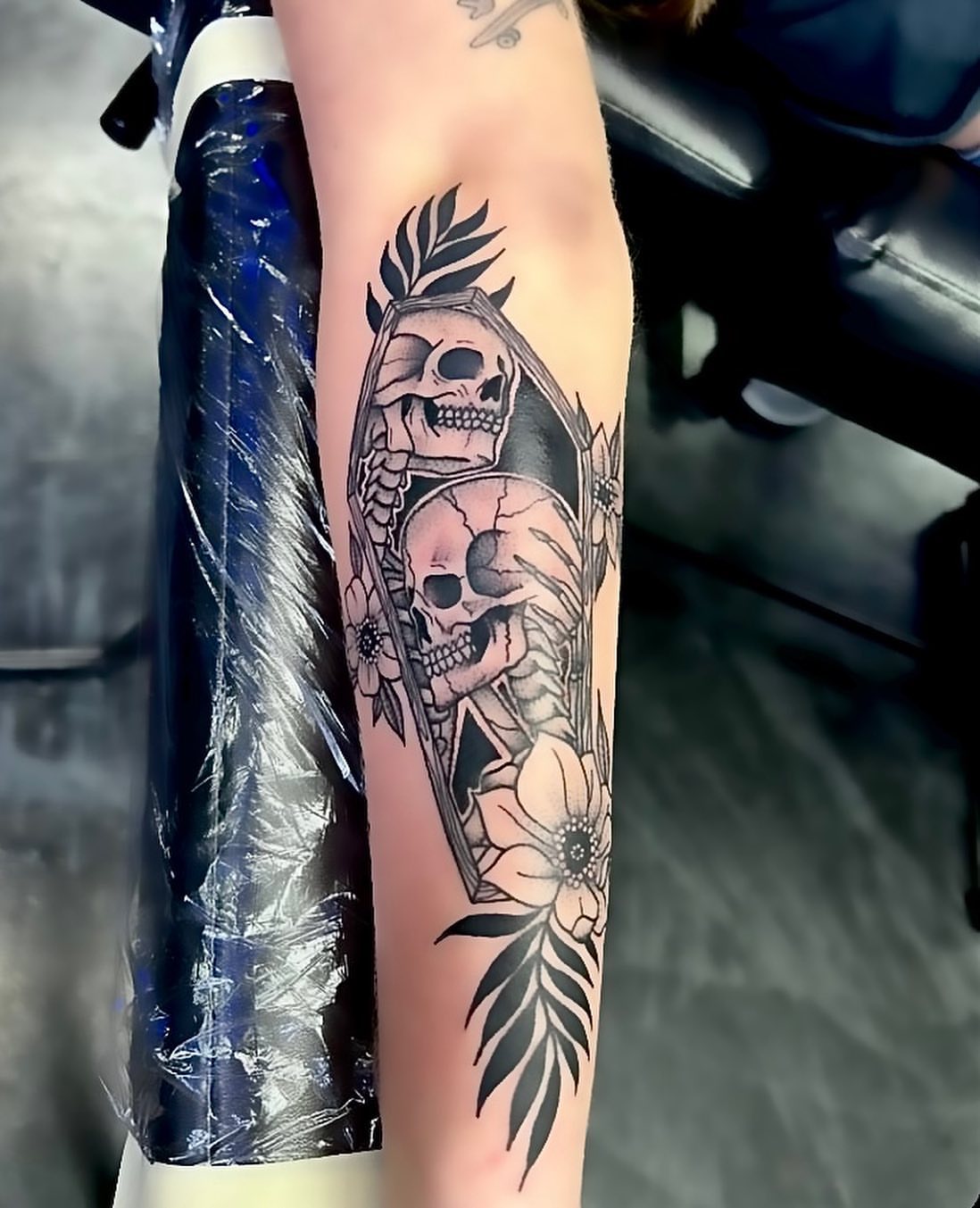 Skulls and flowers realism tattoo on the forearm by Colby McClain