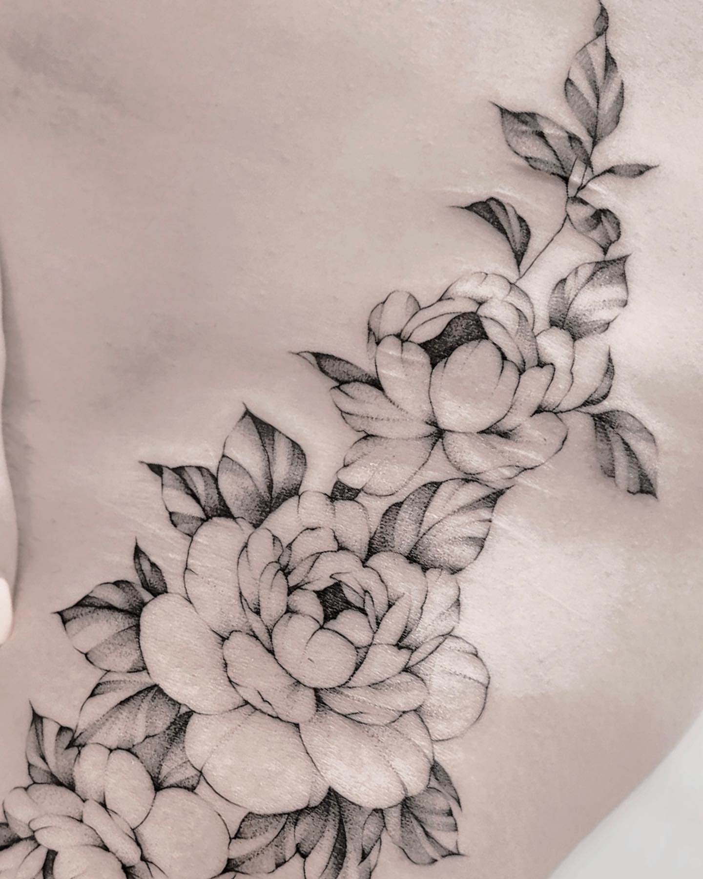 Peony flowers black and grey tattoo on the chest by Houston Tattoo Artist