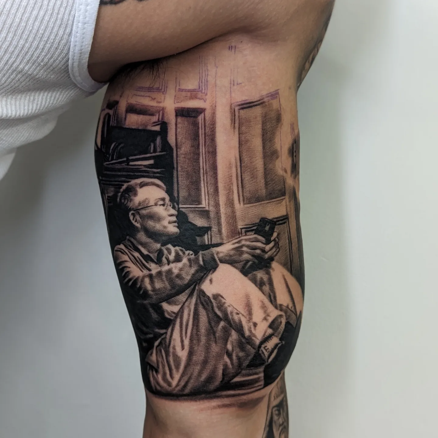 Man reading realism tattoo on the forearm by Sean Costello