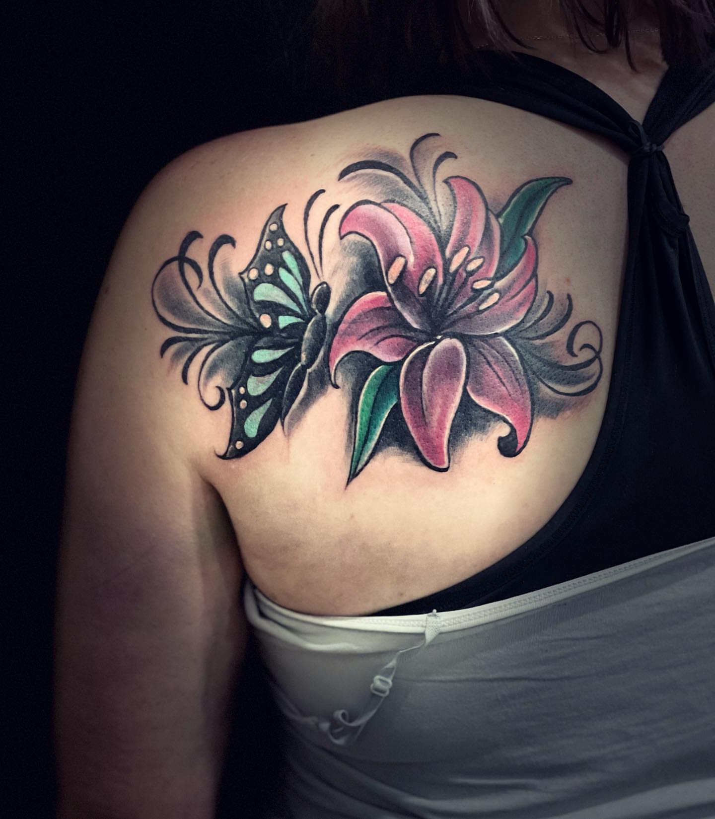Lily and butterfly American traditional tattoo on the shoulder by Peewee Morales