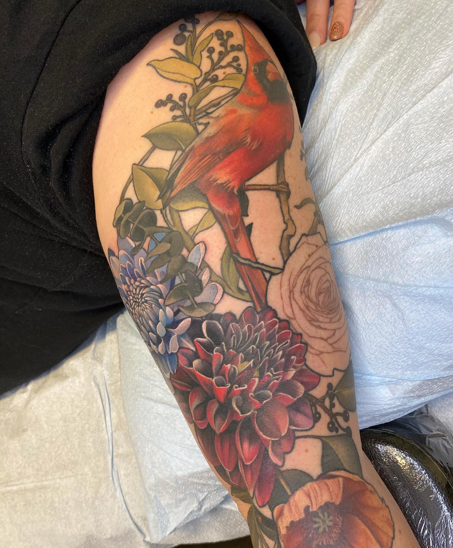 Cardinal and flowers realism tattoo on the thigh by Anali De Laney