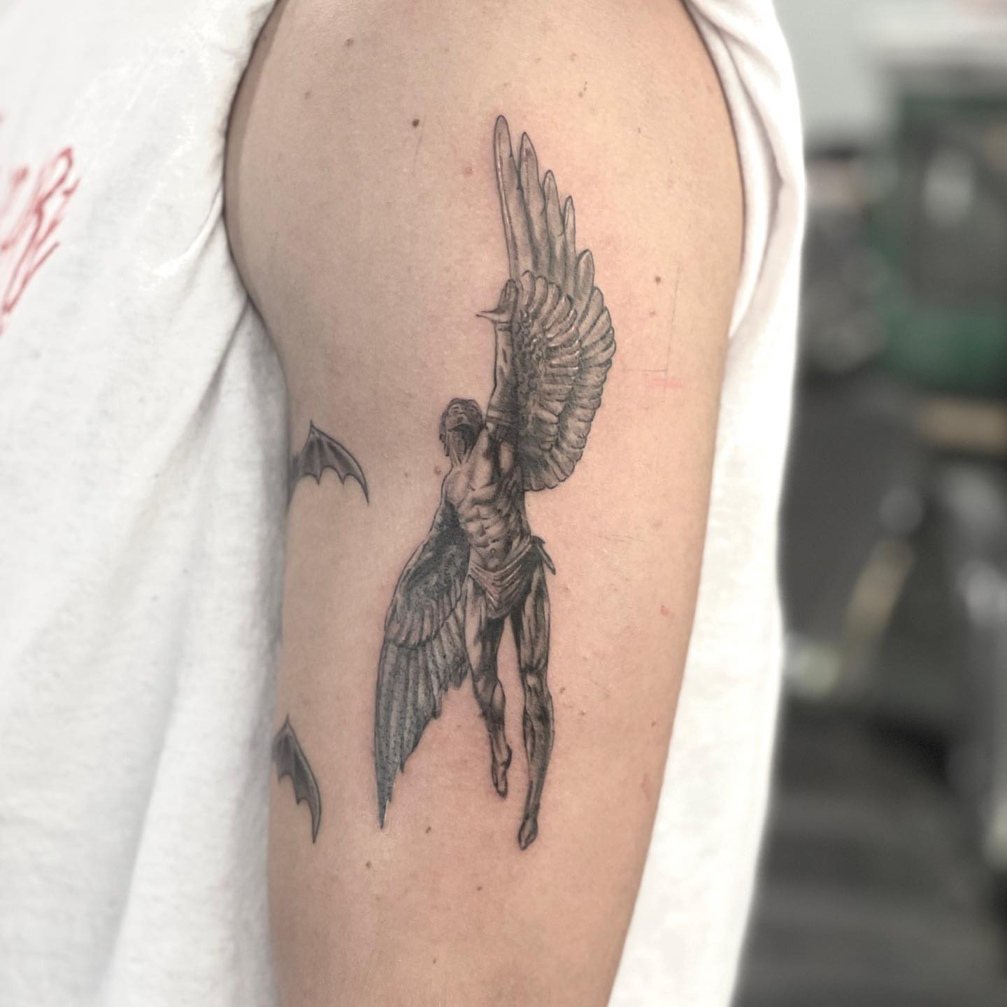 Winged angel black and grey tattoo on the upper arm by Zachary Kaufhold