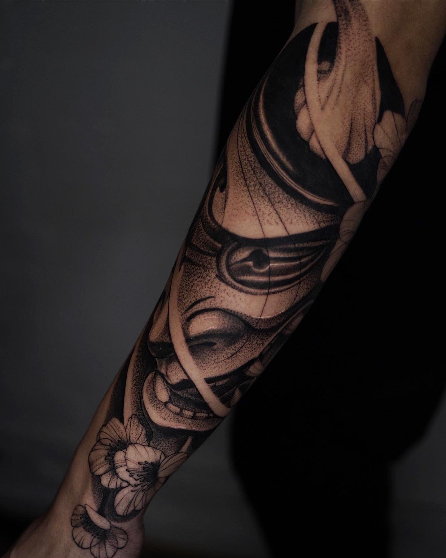 Mask and flowers dotwork tattoo on the forearm by Manuel Alejandro Maldonado