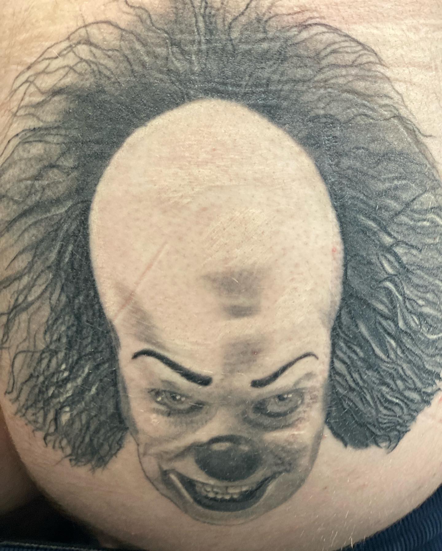 Clown face realism tattoo on the torso by Alberto Ramirez