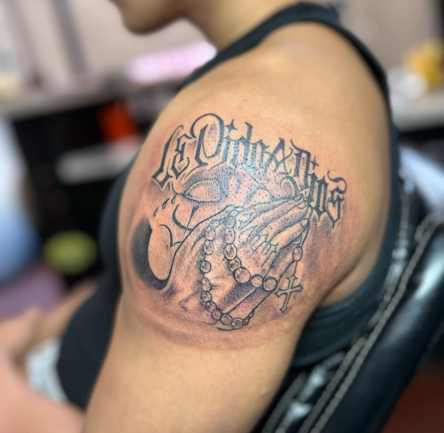 Praying hands with rosary black and grey tattoo on the shoulder by Felix perez (Tattooer)