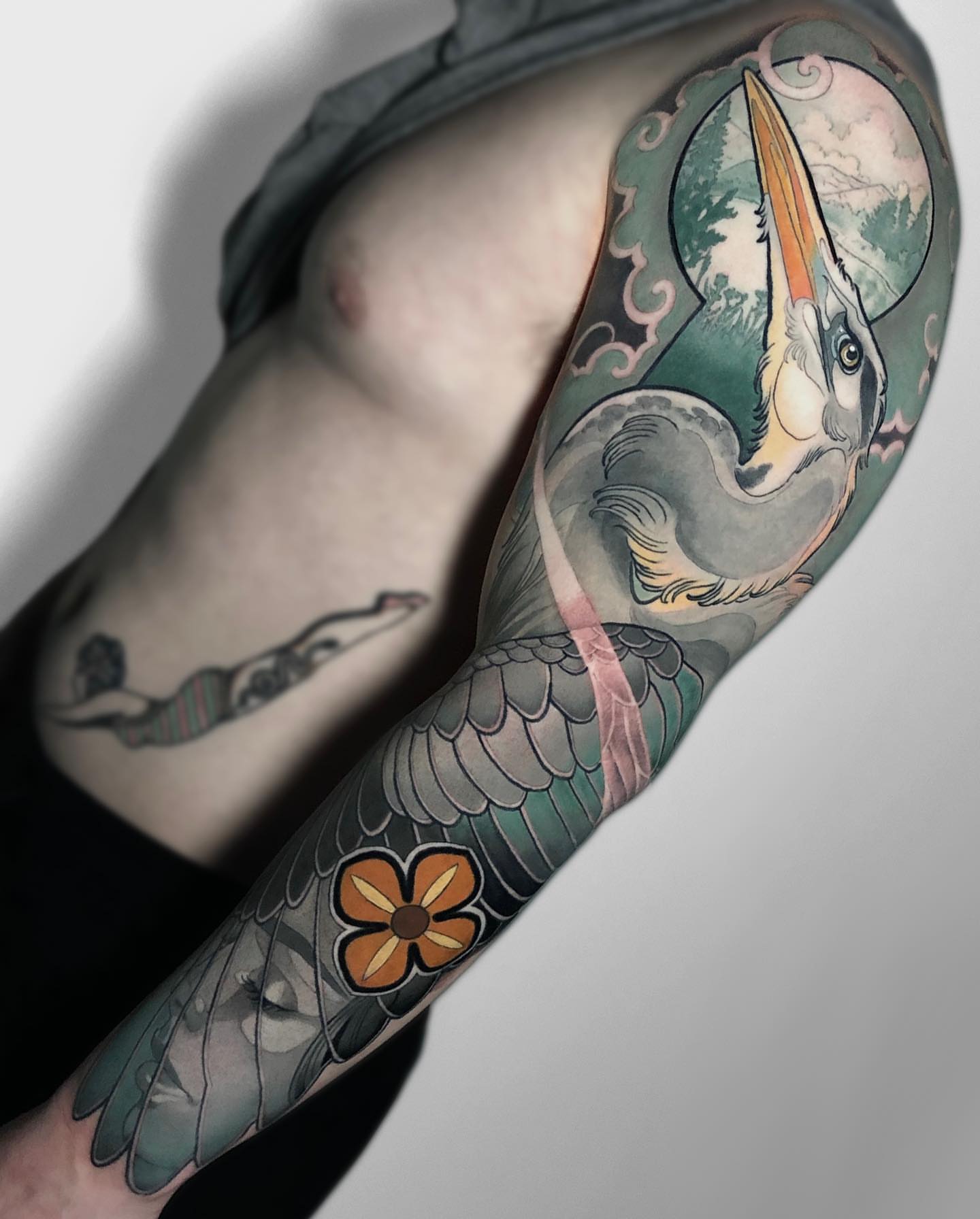 Pelican and flower American traditional tattoo on the forearm by Levi Murphy