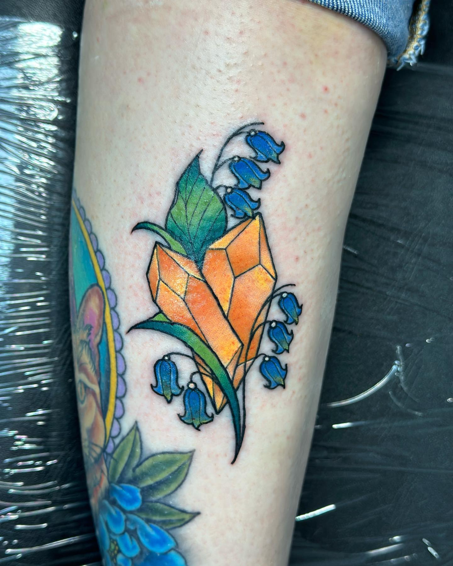 Lily of the valley and crystal geometric tattoo on the leg by alex h🪴 neotrad