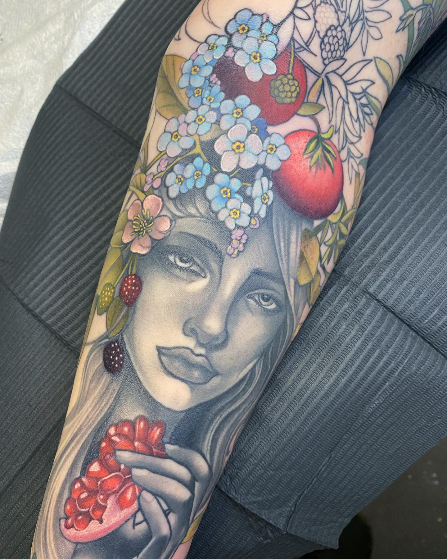 Woman with floral crown realism tattoo on the forearm by Anali De Laney