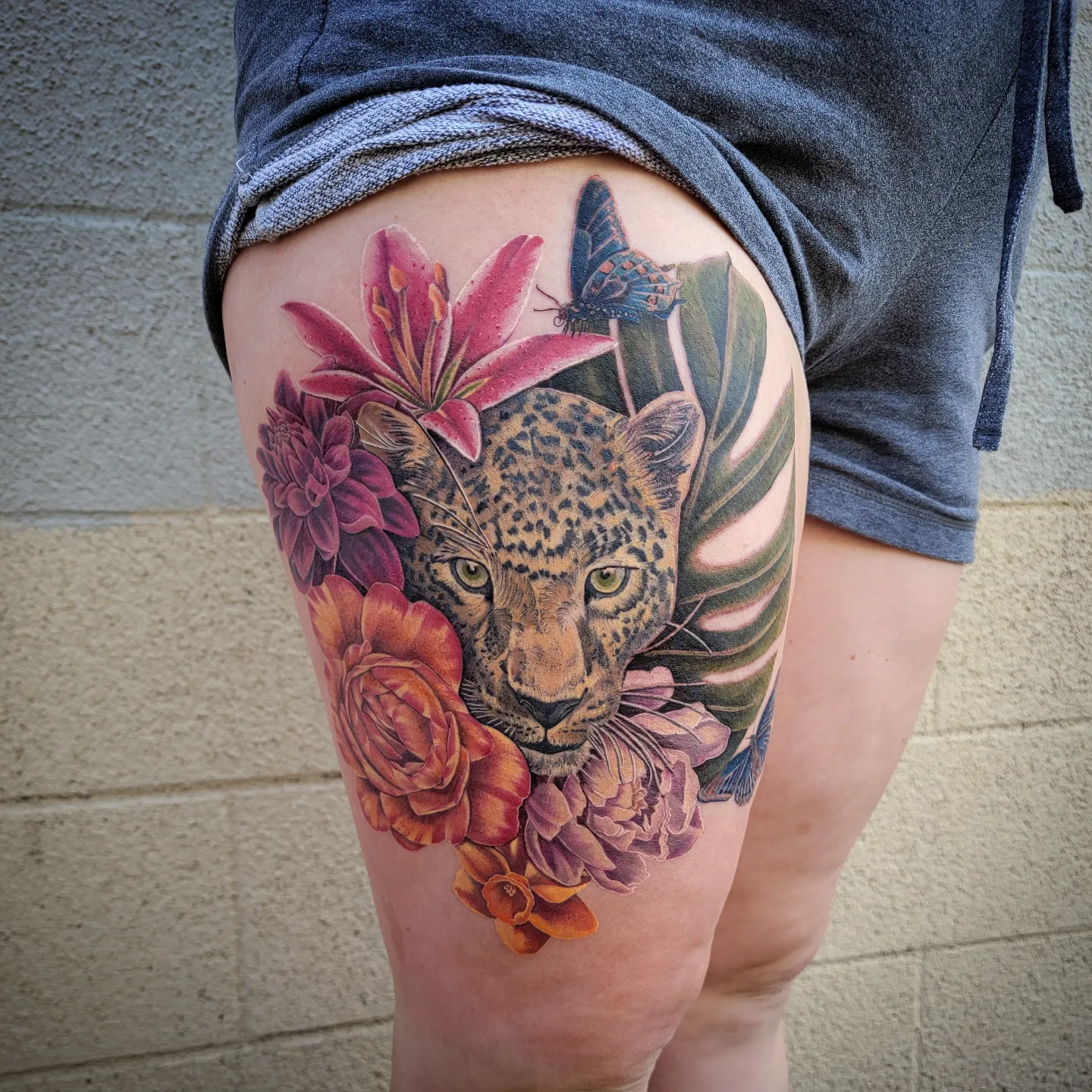 Jaguar with flowers realism tattoo on the thigh by Shar - Utah Tattoo Artist