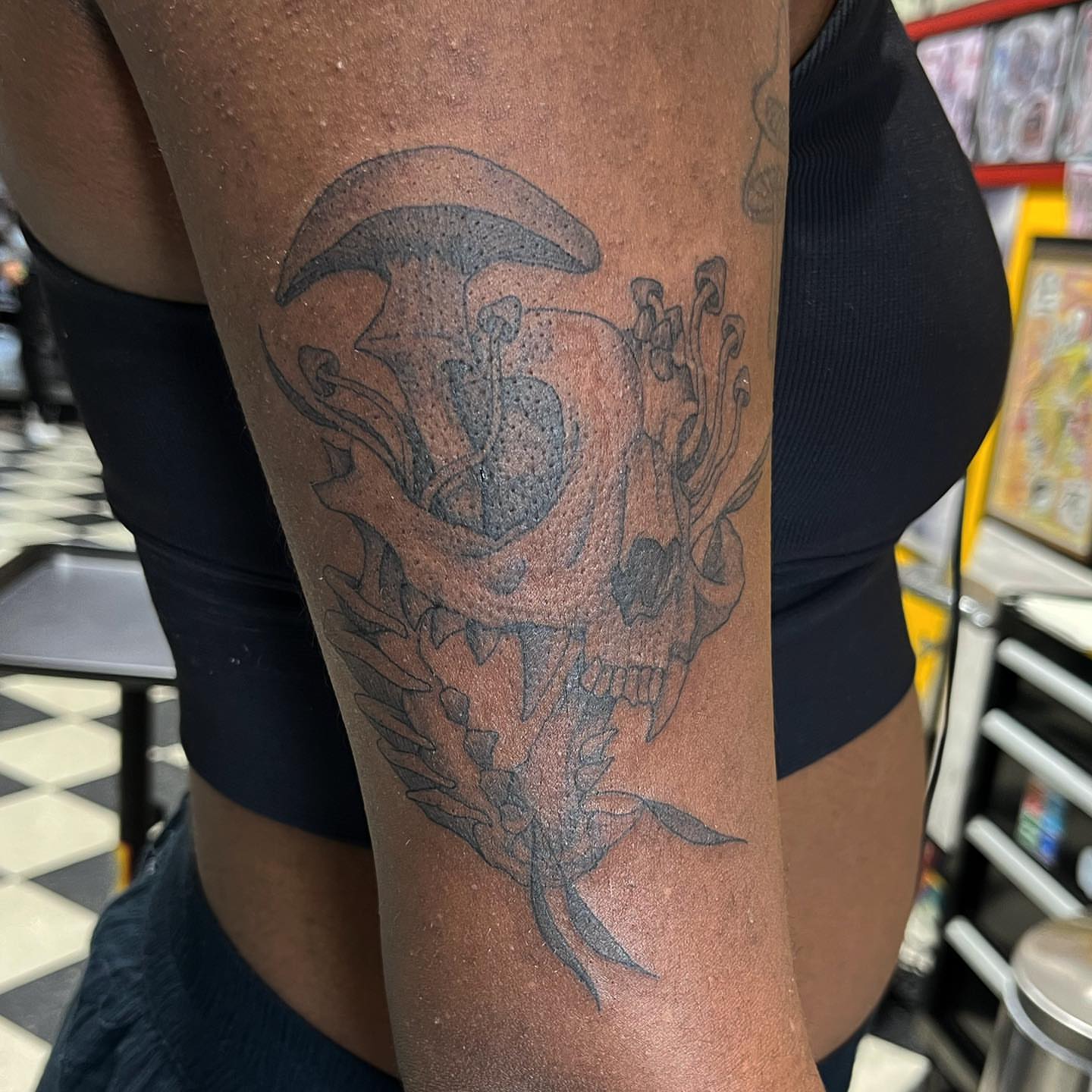 Skull and mushroom black and grey tattoo on the forearm by Morgan Jones