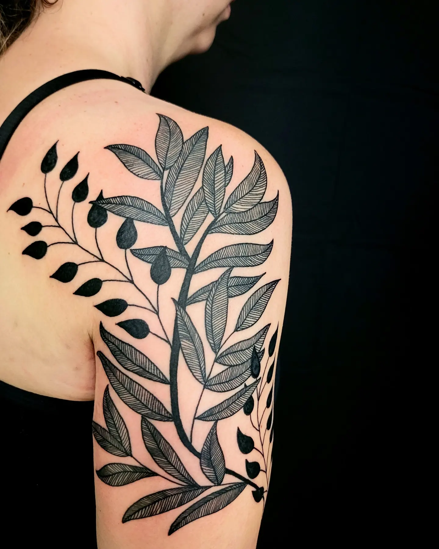 Branch with leaves black and grey tattoo on the shoulder by Nicole Bett