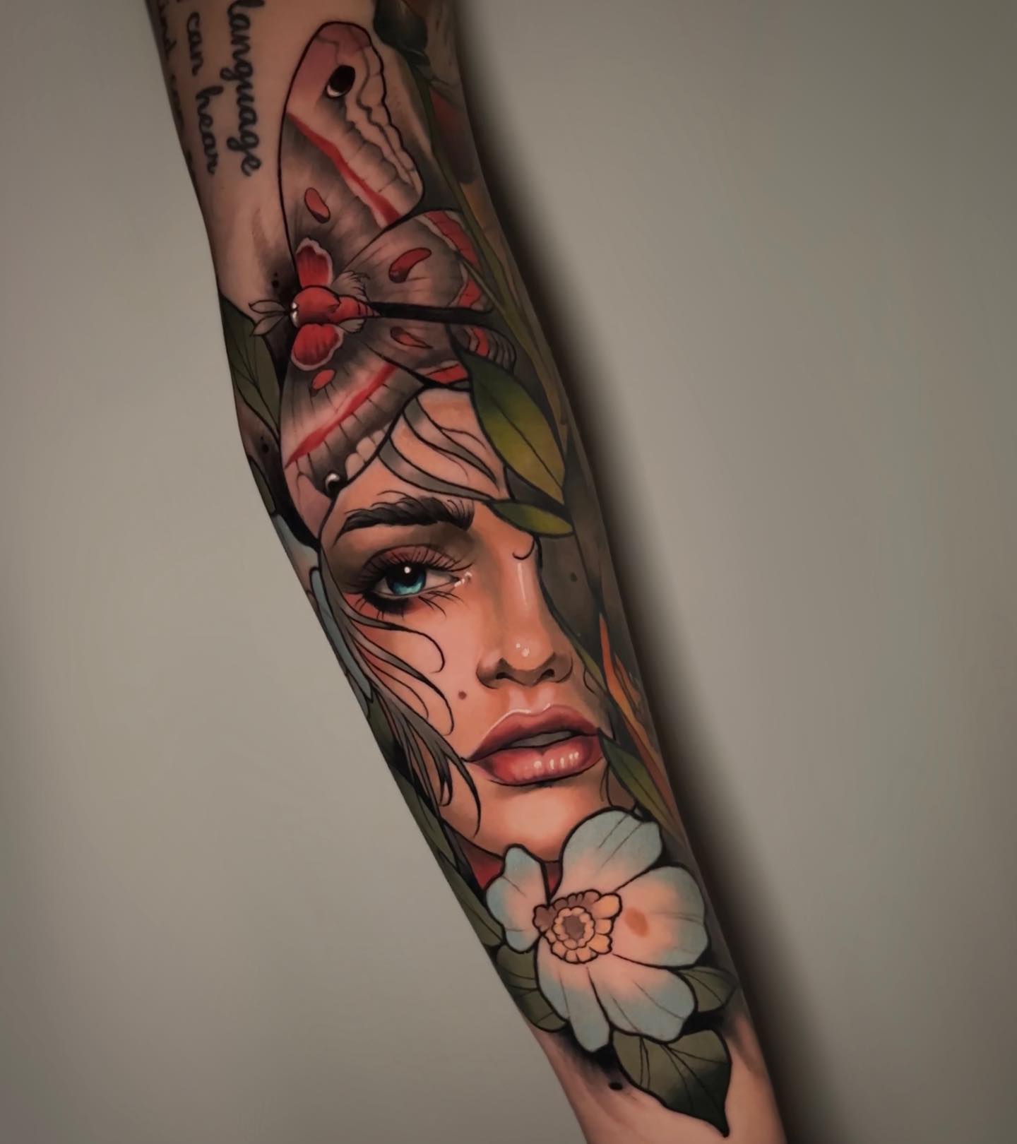 Woman with moth and flower neo-traditional tattoo on the forearm by Andrey