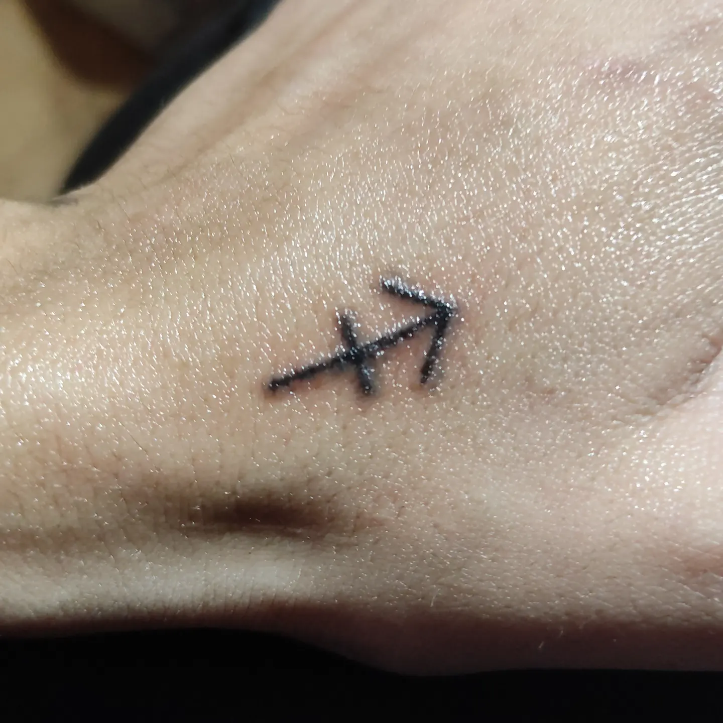 Sagittarius symbol black and grey tattoo on the forearm by Tatuadora & Piercer
