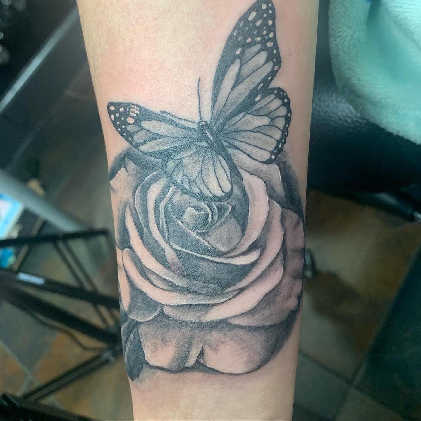 Rose and butterfly realism tattoo on the forearm by Haley