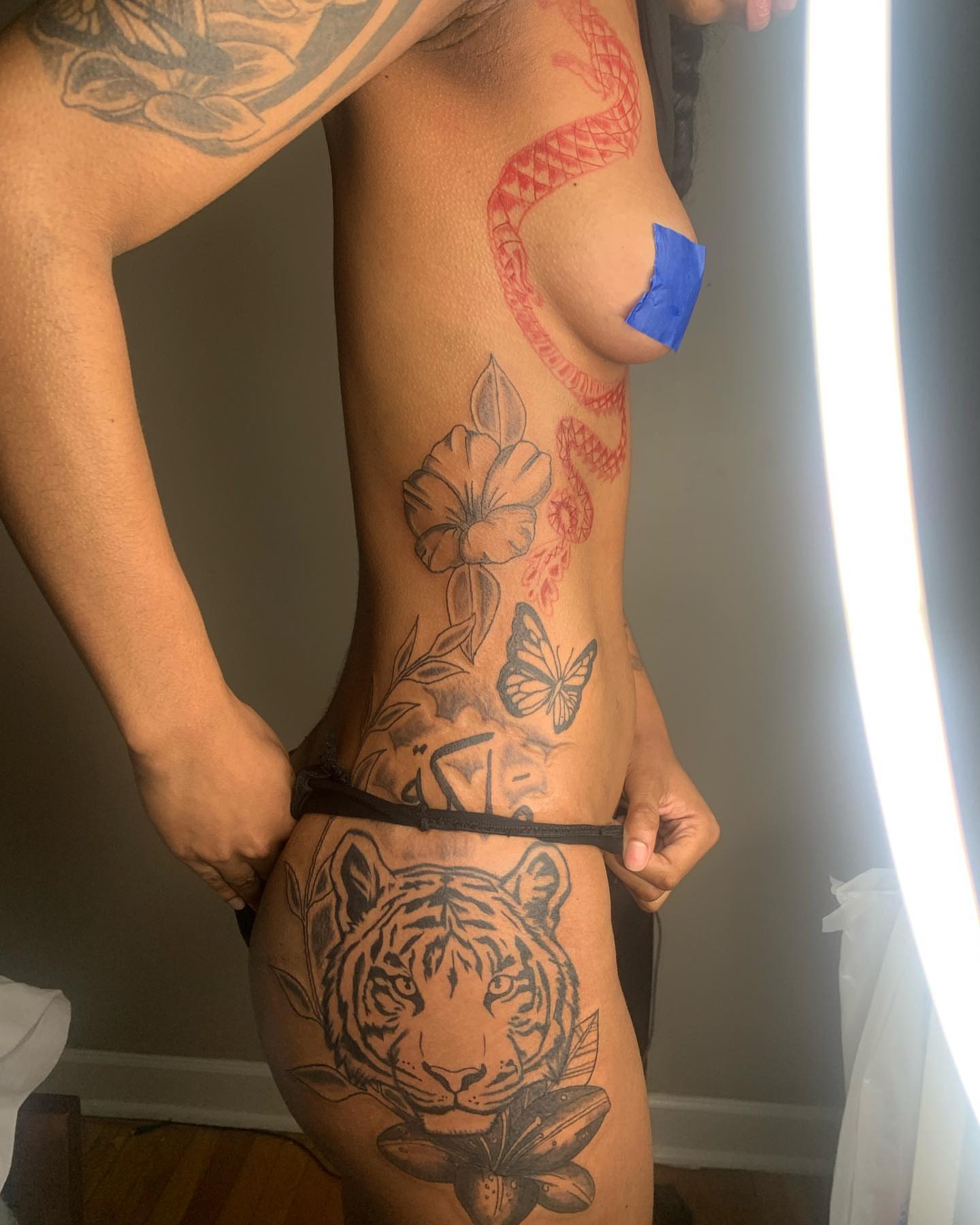 Tiger and floral black and grey tattoo on the thigh by Evan Chastain