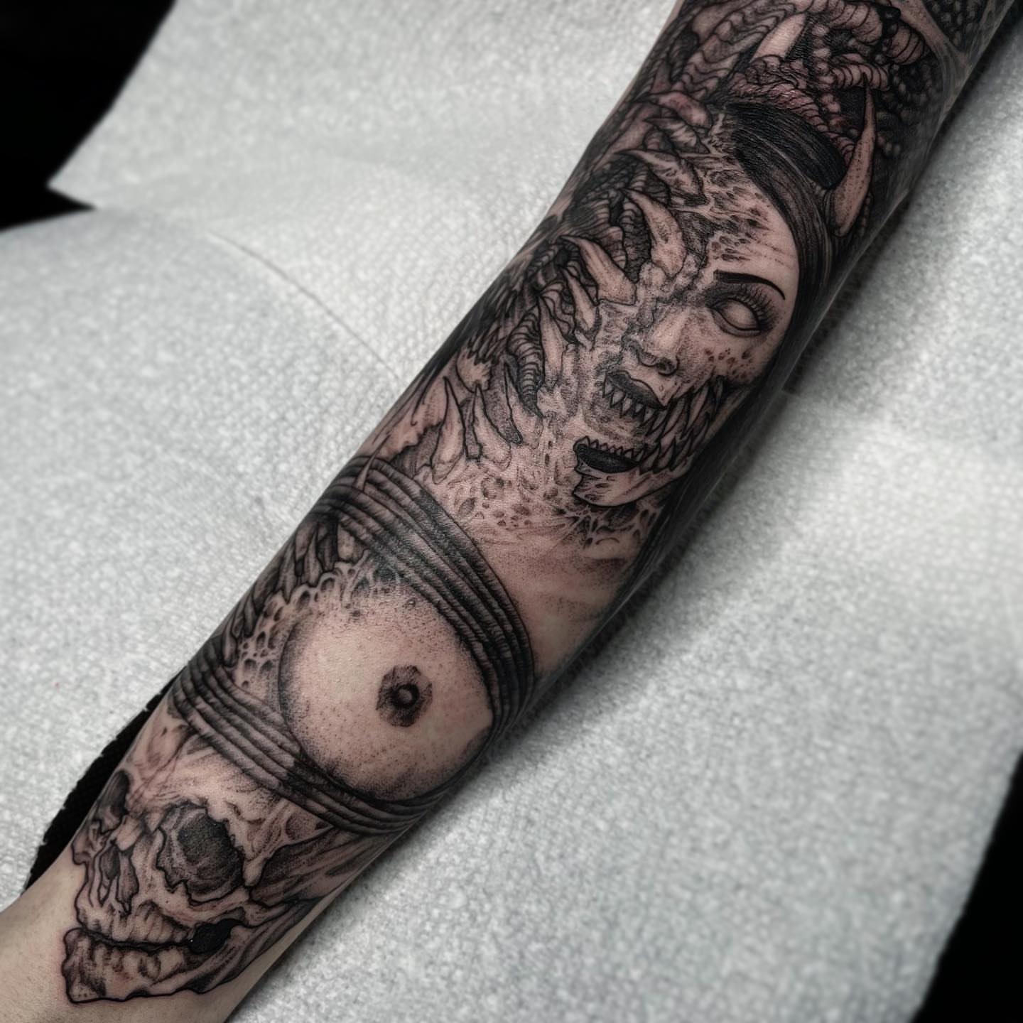 Female face with dragon realism tattoo on the forearm by Kyle Black