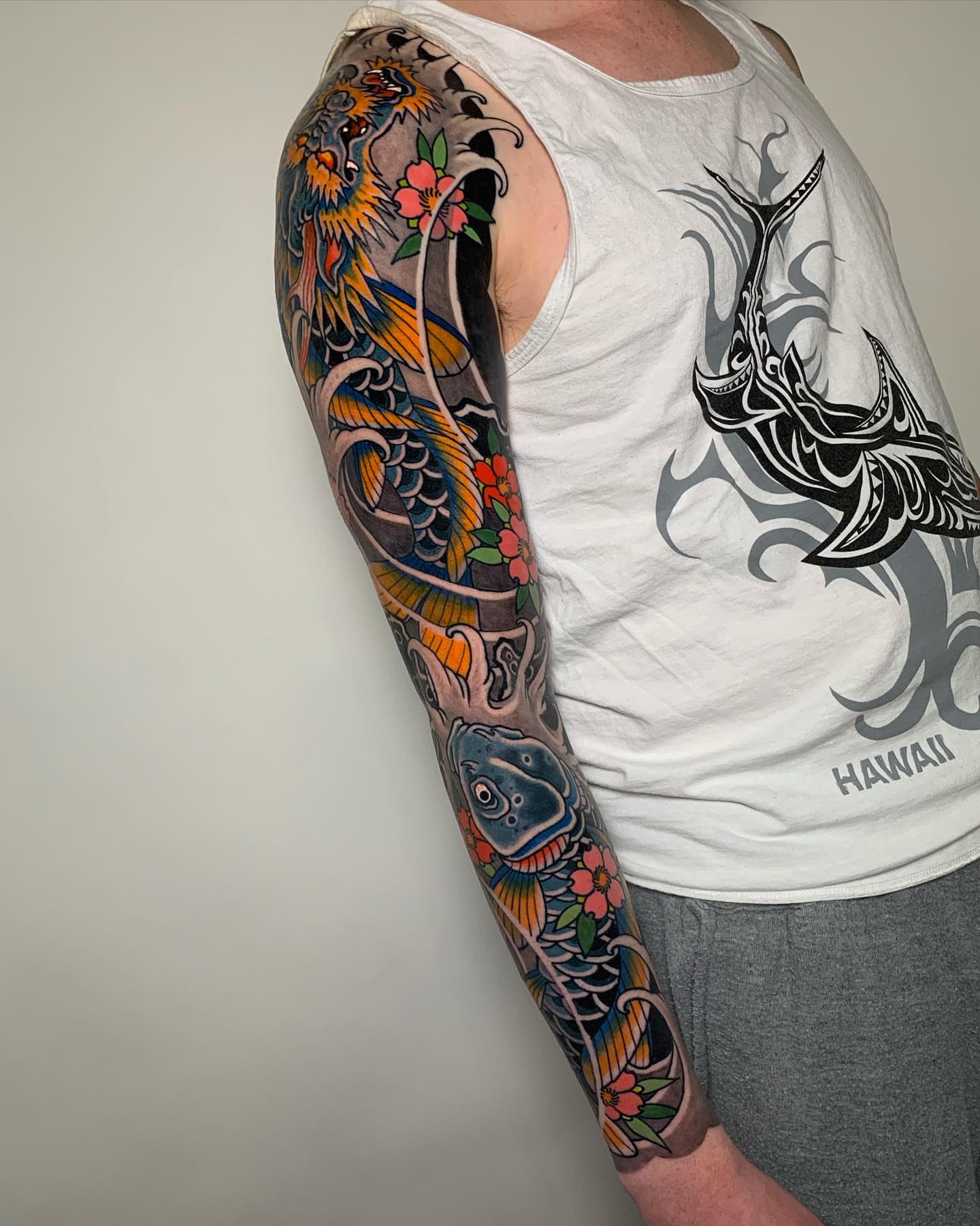 Koi fish and flowers japanese irezumi tattoo on the upper arm by Forrest Henderson 森
