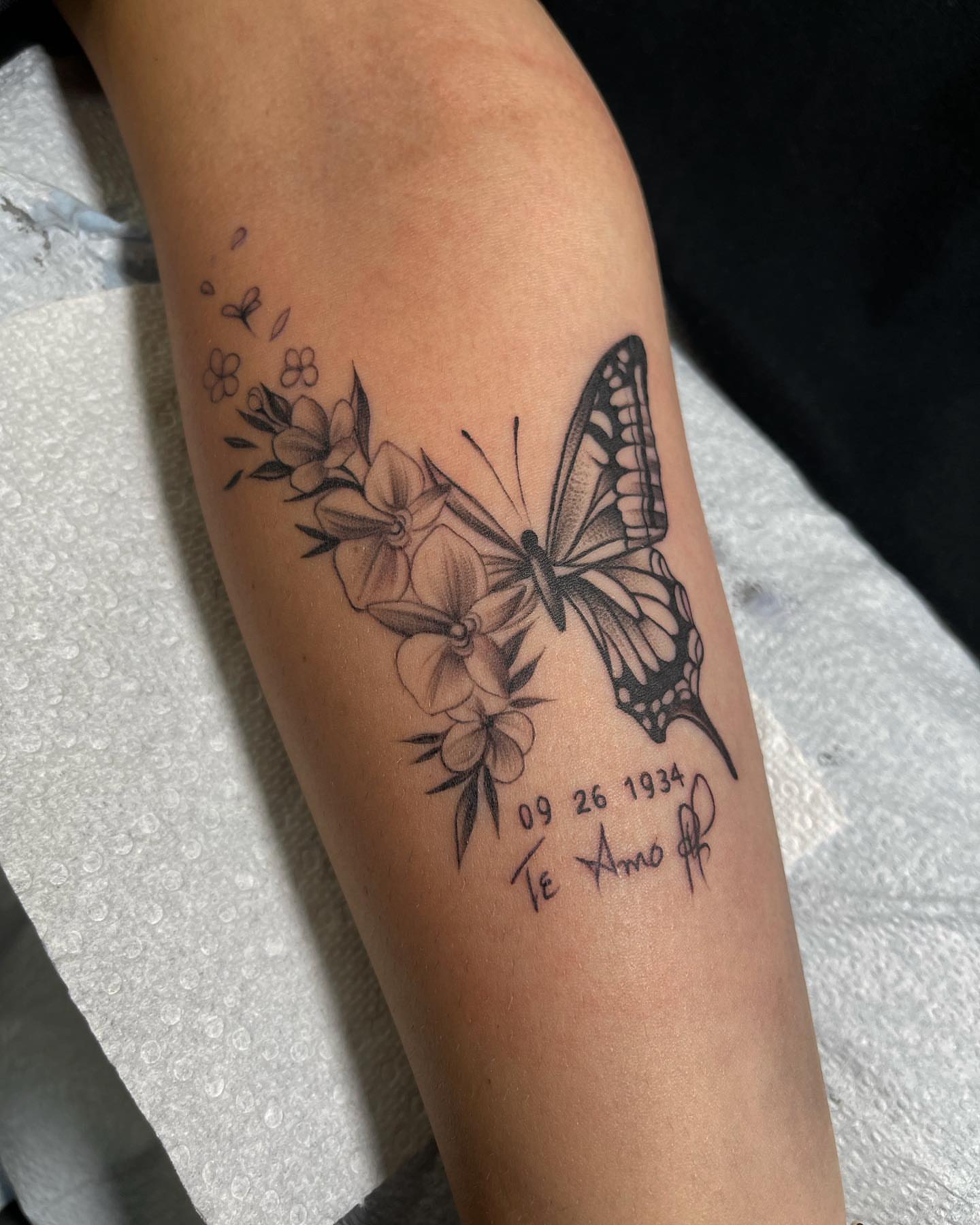 Butterfly and flowers black and grey tattoo on the forearm by Carla V