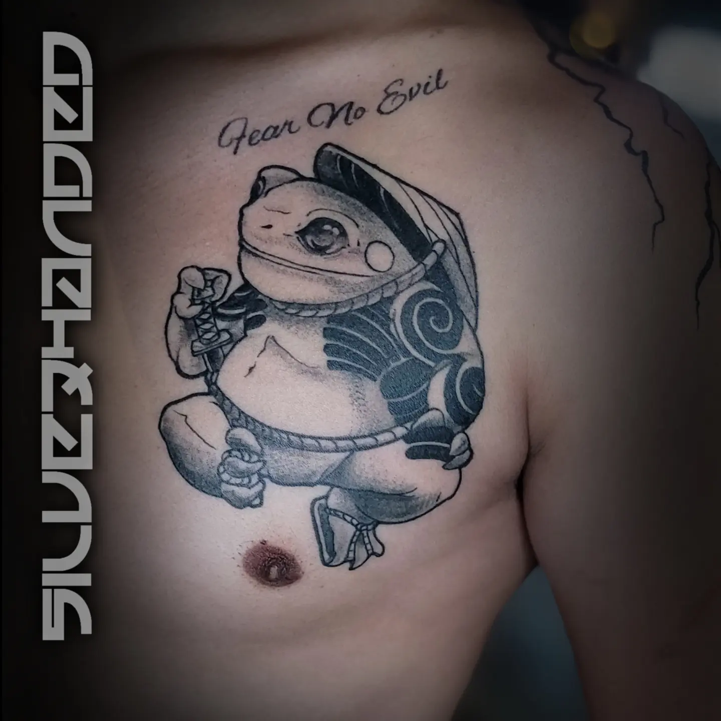 Toad black and grey tattoo on the chest by Tj Silverhand