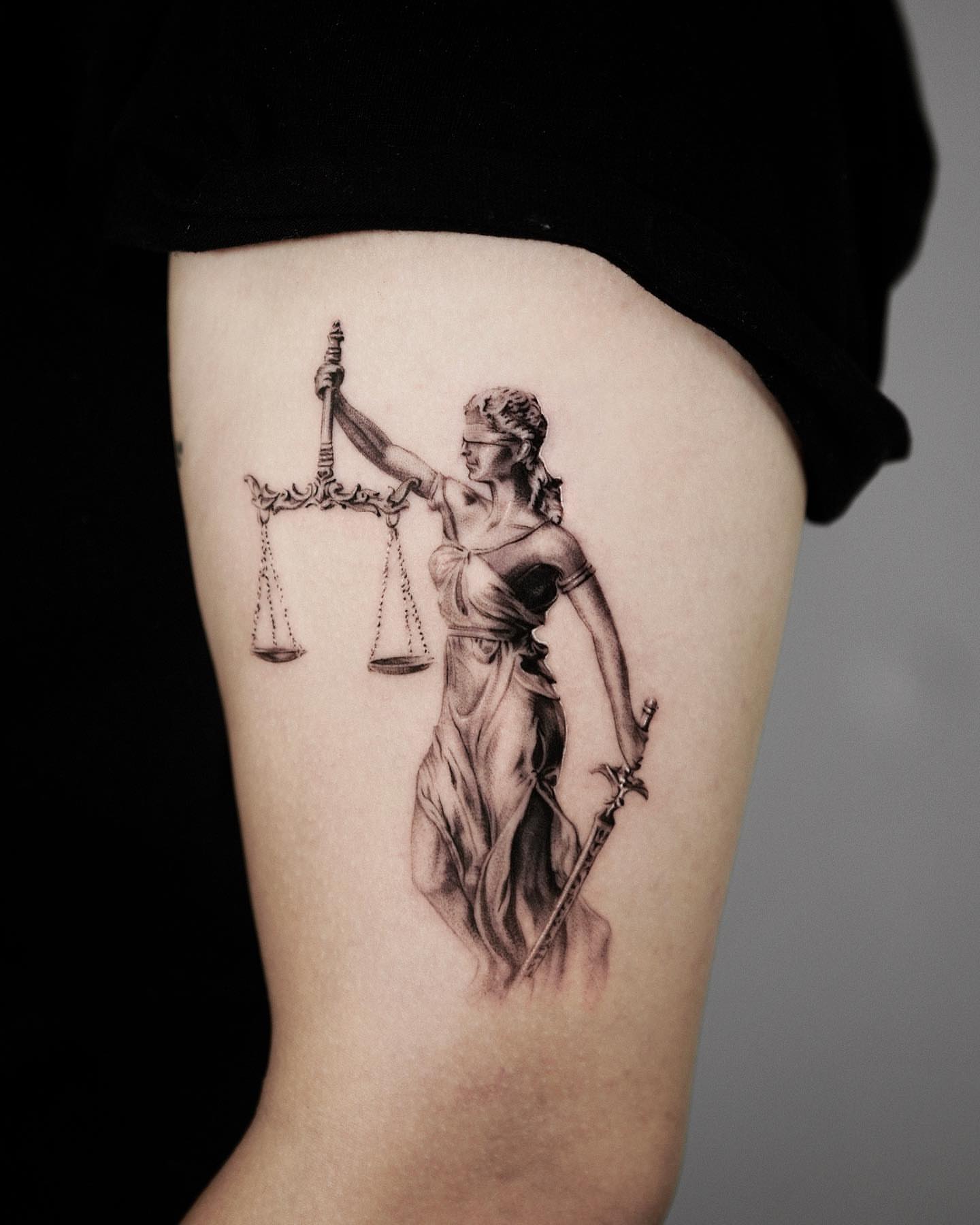 Scale of justice realism tattoo on the thigh by Kid Needle