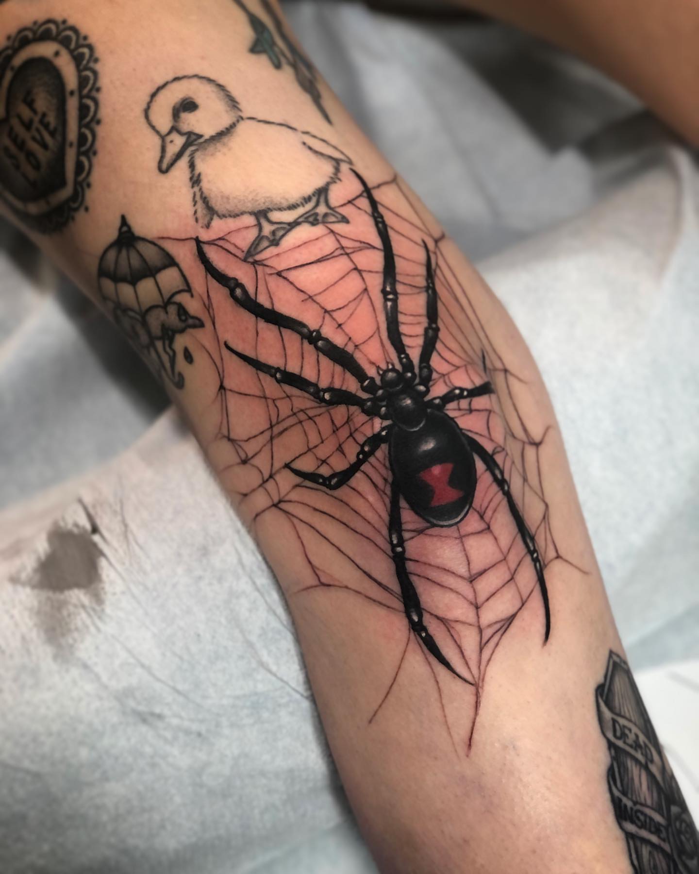 Spider web realism tattoo on the forearm by Alec Bauer