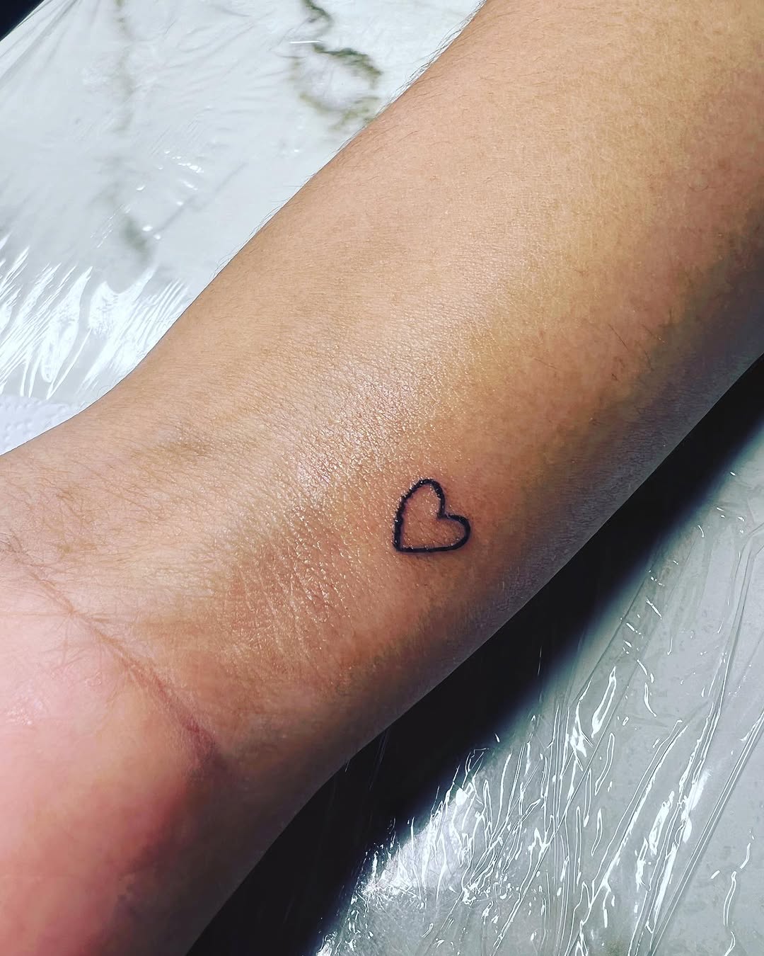 Outline heart minimalist tattoo on the forearm by CmoreInk