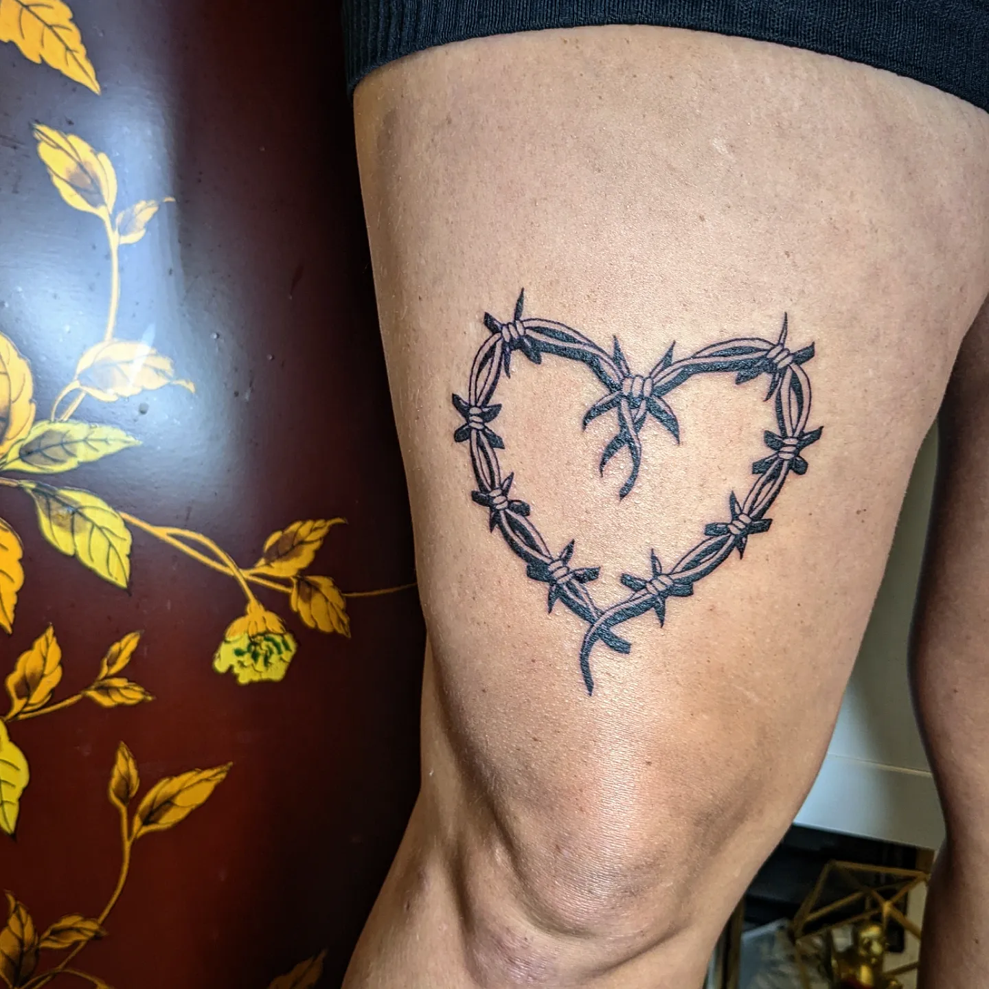 Barbed wire heart black and grey tattoo on the thigh by Aim 🤍