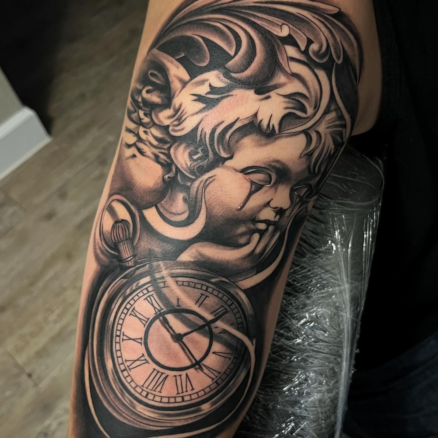 Clock and cherub realism tattoo on the forearm by Christopher McGlone