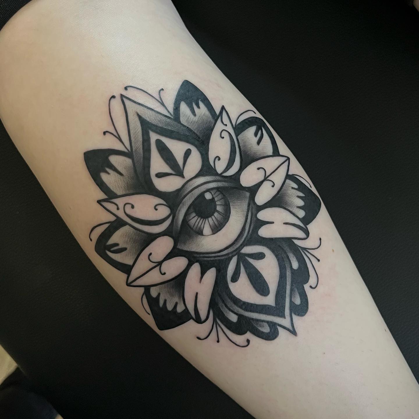 Eye with floral pattern black and grey tattoo on the forearm by Christopher McGlone