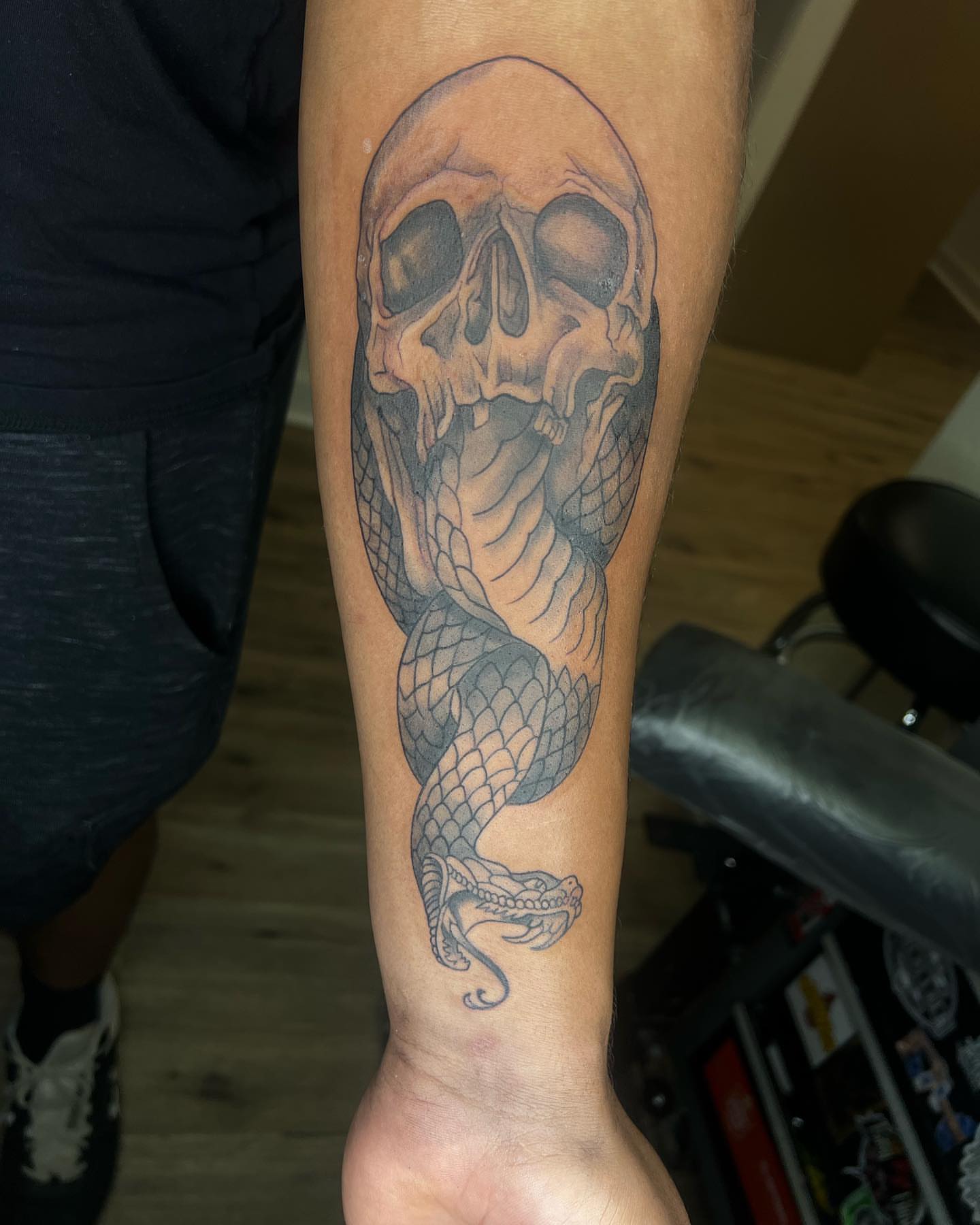 Skull and snake realism tattoo on the forearm by Daphne Landry