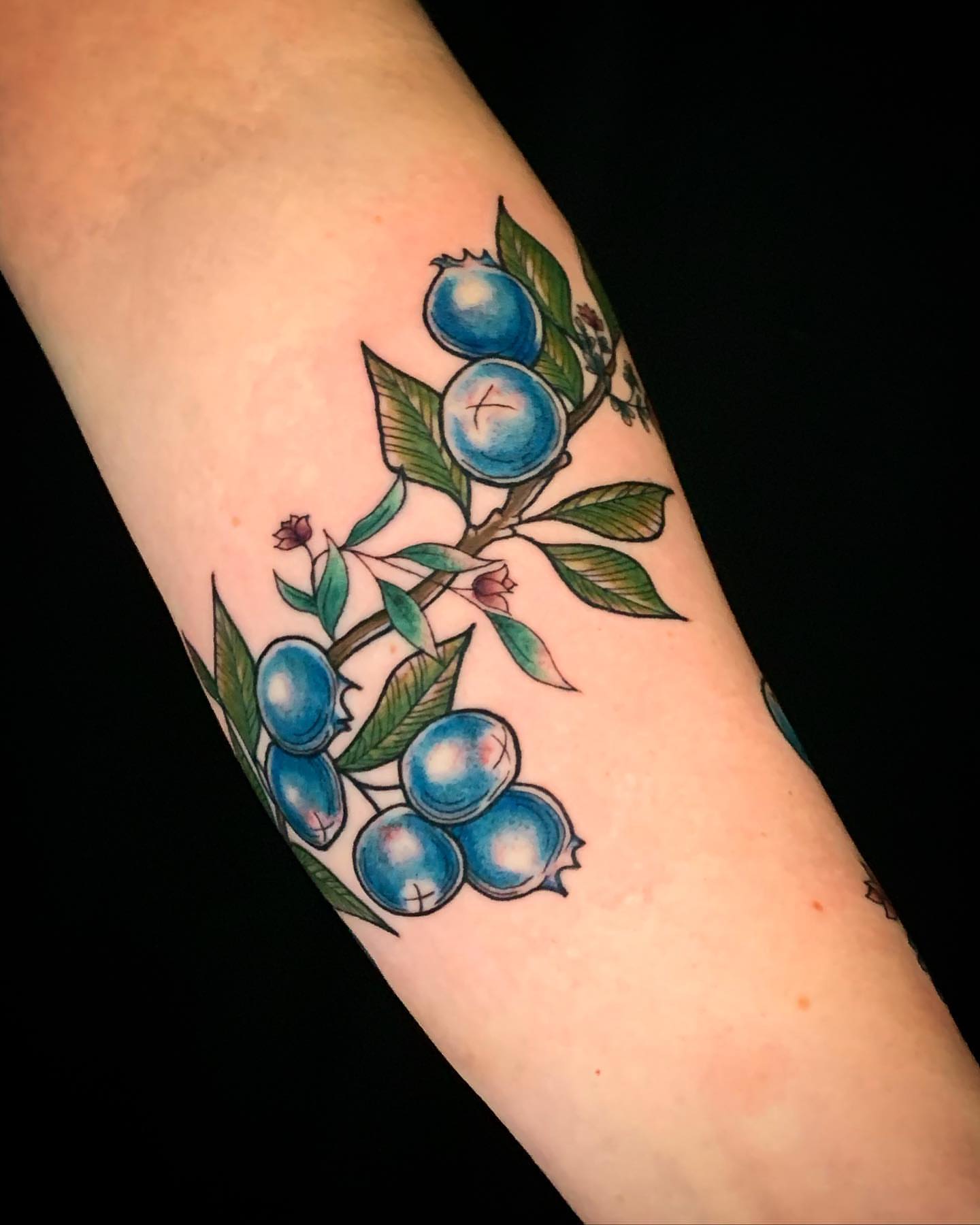 Blueberries and leaves realism tattoo on the forearm by Crystal Thorns