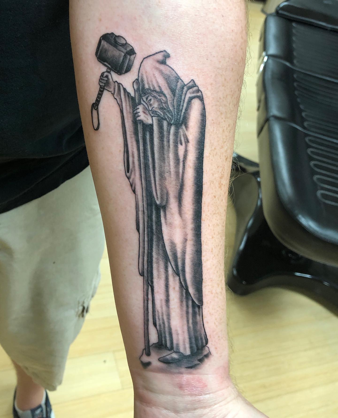 Thor hammering black and grey tattoo on the forearm by Zac Presley