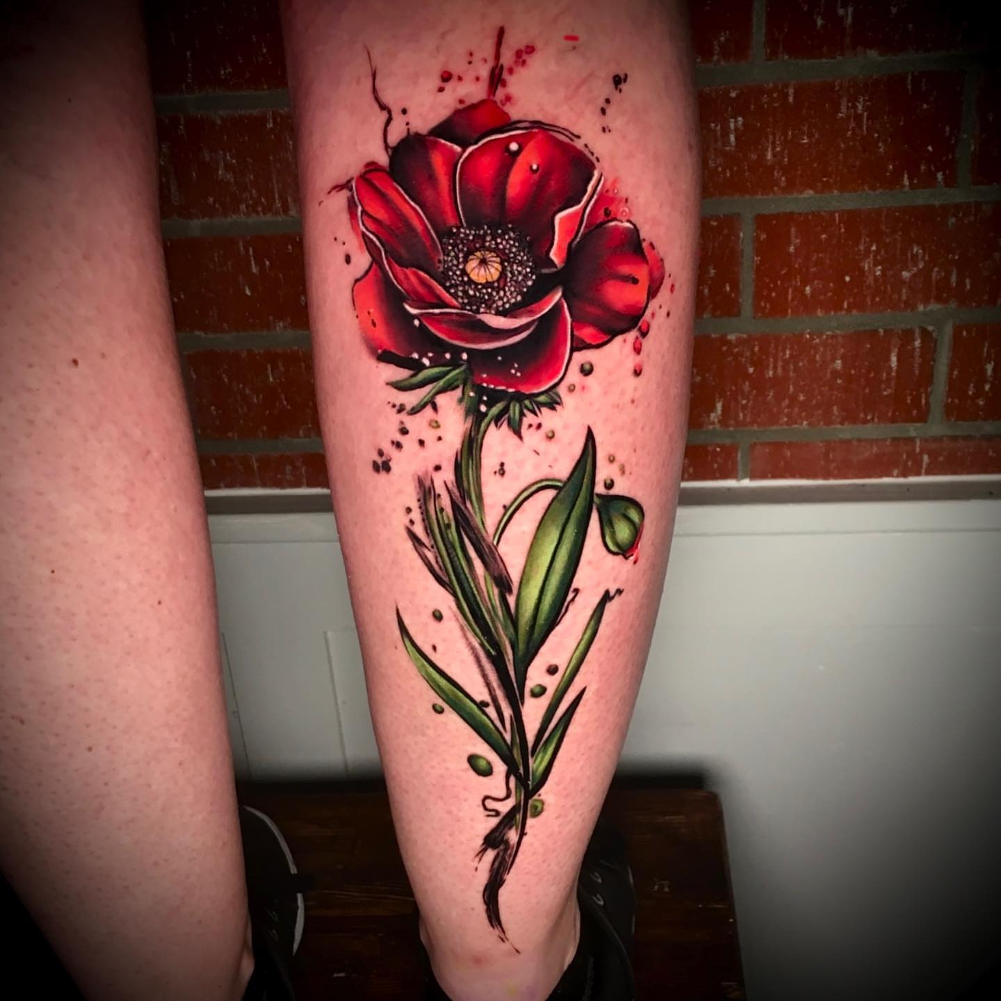 Red poppy dotwork tattoo on the calf by Ray Marie