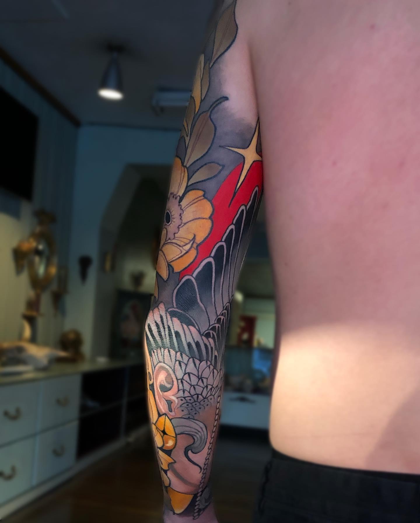 Koi fish and floral American traditional tattoo on the forearm by Levi Murphy