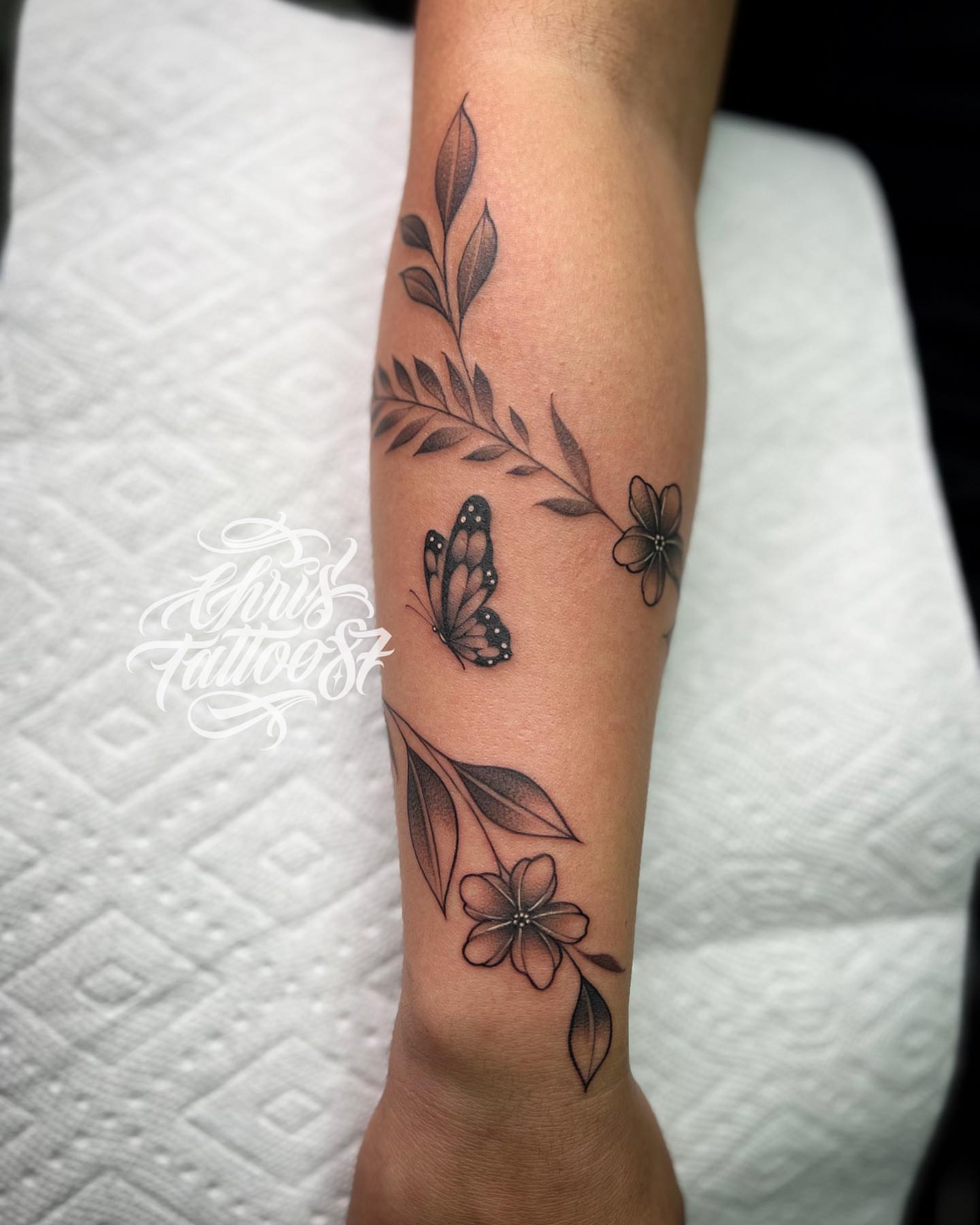 Butterfly and flowers realism tattoo on the forearm by chris tattoo
