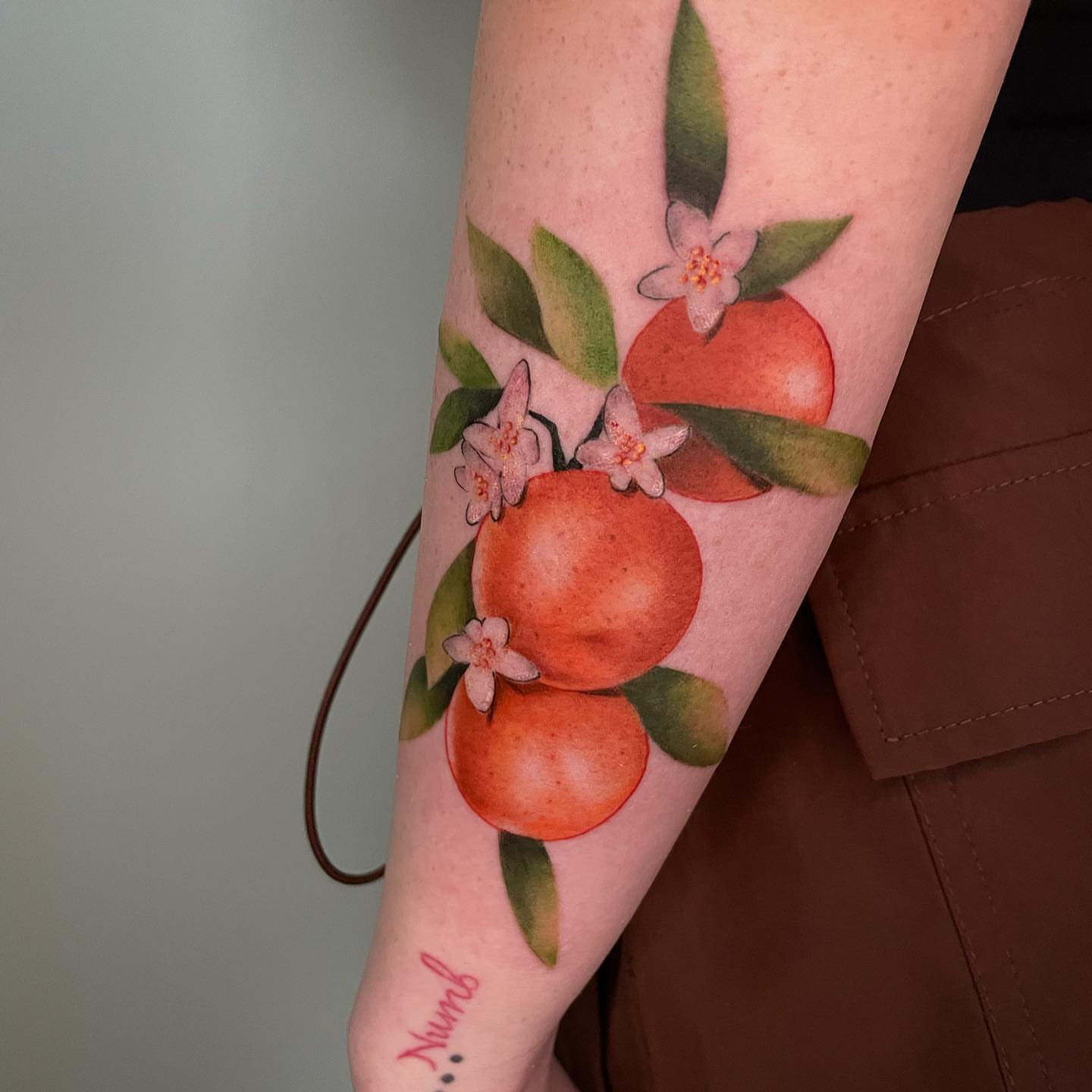 Oranges and flowers watercolor tattoo on the forearm by Angel, Salt Lake City, Utah