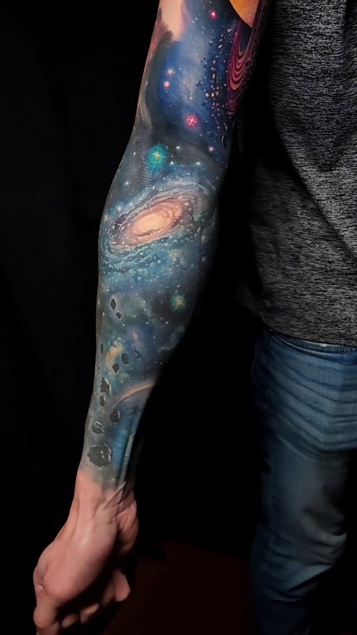 Cosmic sleeve with planets and galaxies realism tattoo by Tyler Malek