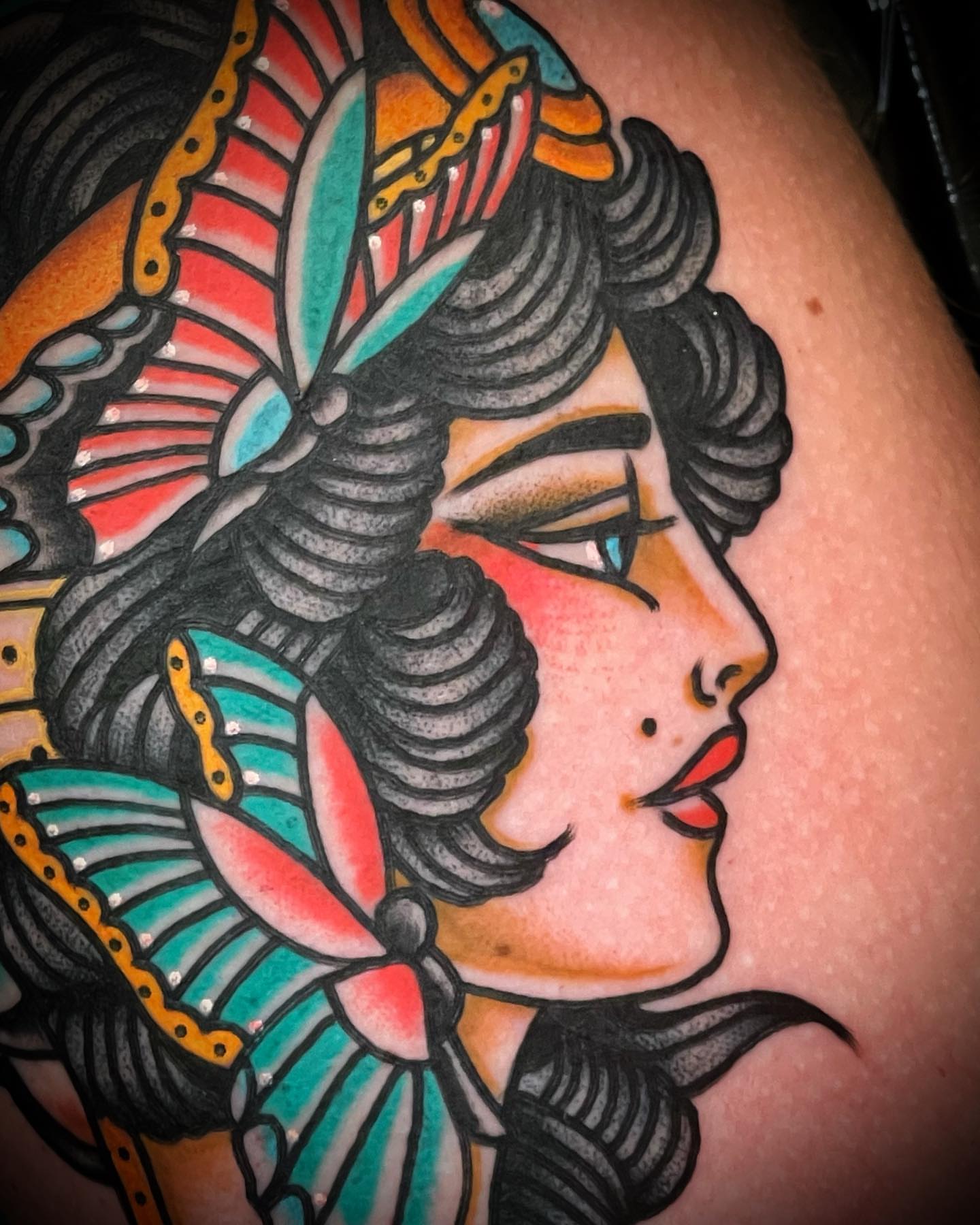 Woman with headdress American traditional tattoo on the shoulder by Alex Muniz