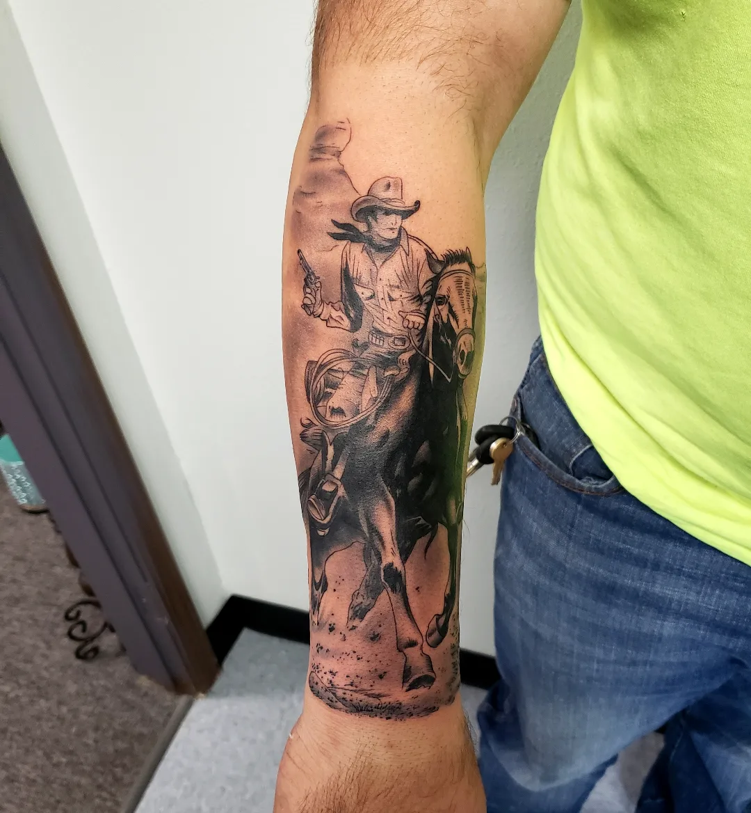 Cowboy on horseback realism tattoo on the forearm by Jake Lee