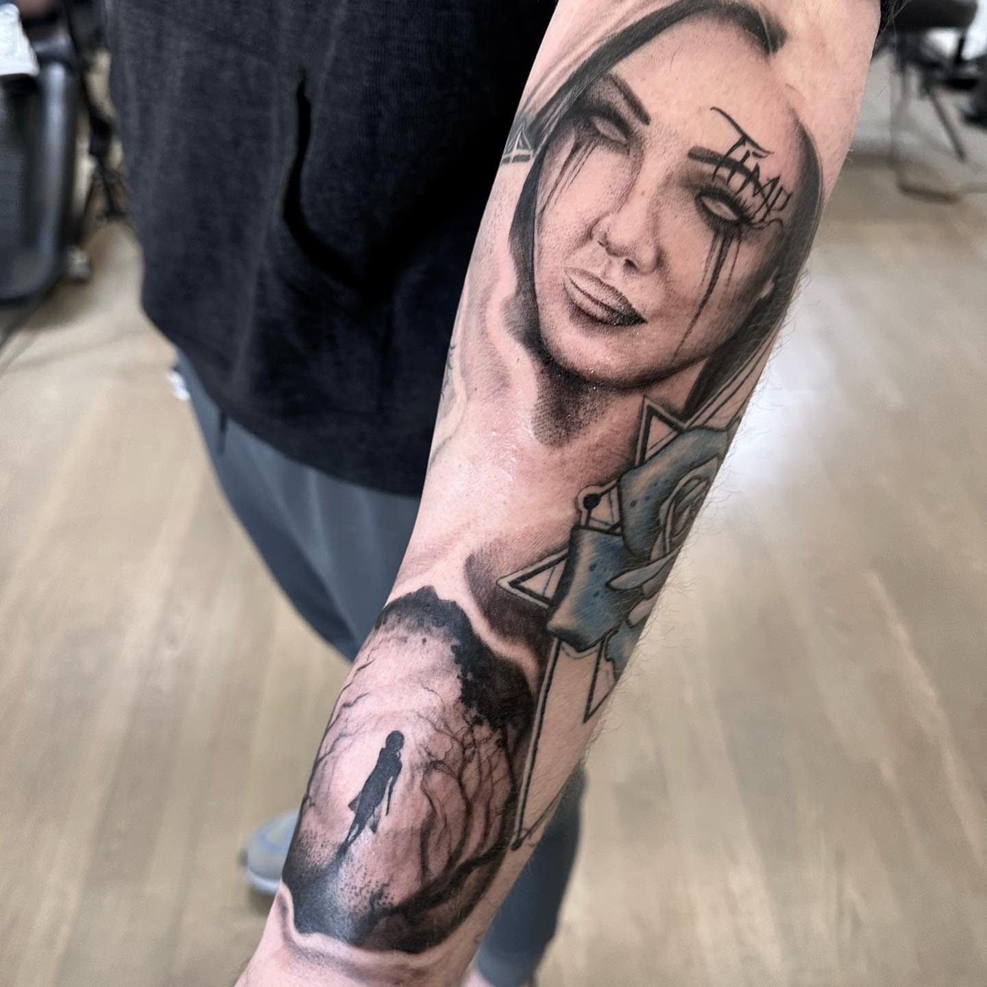 Woman with cross realism tattoo on the forearm by Matthew Clanin