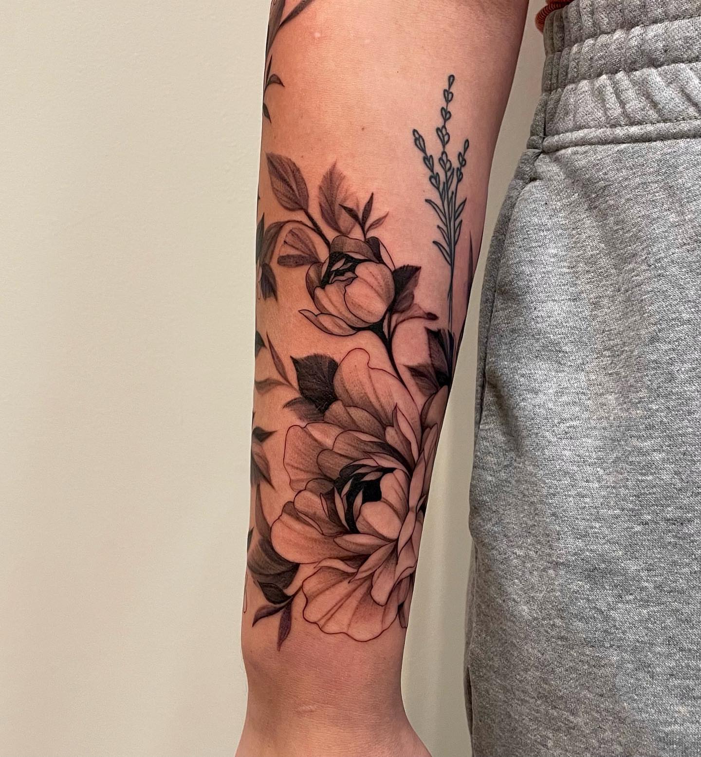 Floral bouquet black and grey tattoo on the forearm by Sam Oakes