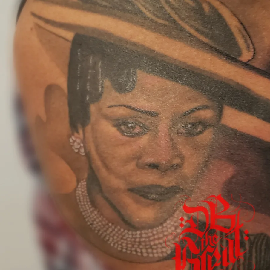 Portrait realism tattoo on the upper arm by Dannie Blythewood