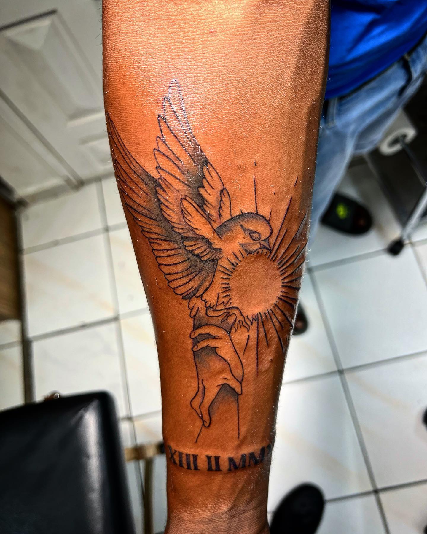 Bird and sun black and grey tattoo on the forearm by oxideTattoo, Morne-à-l'Eau