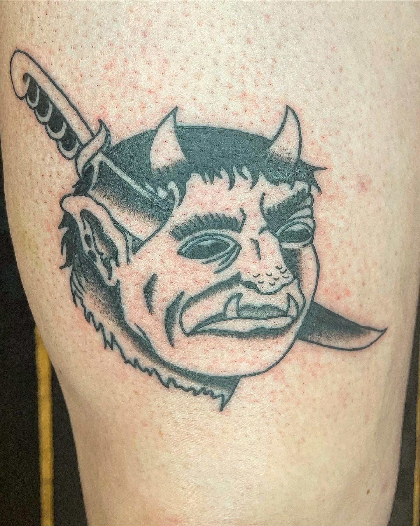 Demon head black and grey tattoo on the thigh by Pedroux M.