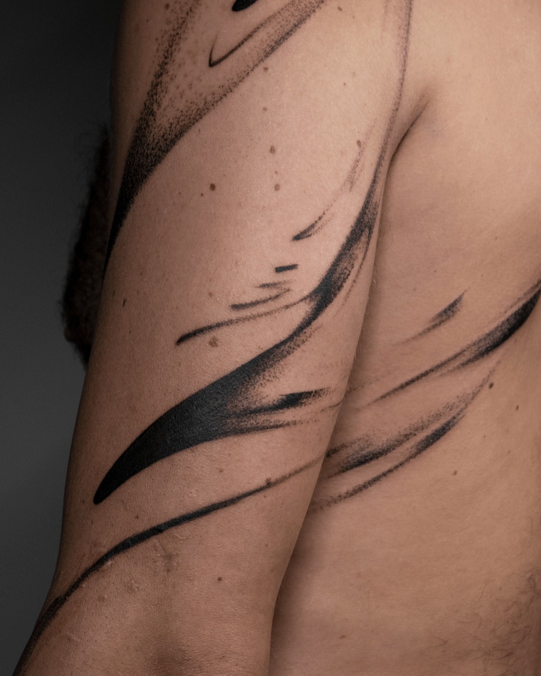 Abstract swirls black and grey tattoo on the upper arm by Pietro Moleti