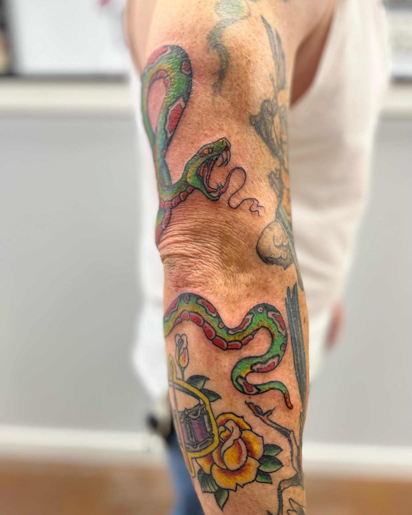 Snake and roses American traditional tattoo on the forearm by Allie Tippets, Gilbert, Arizona