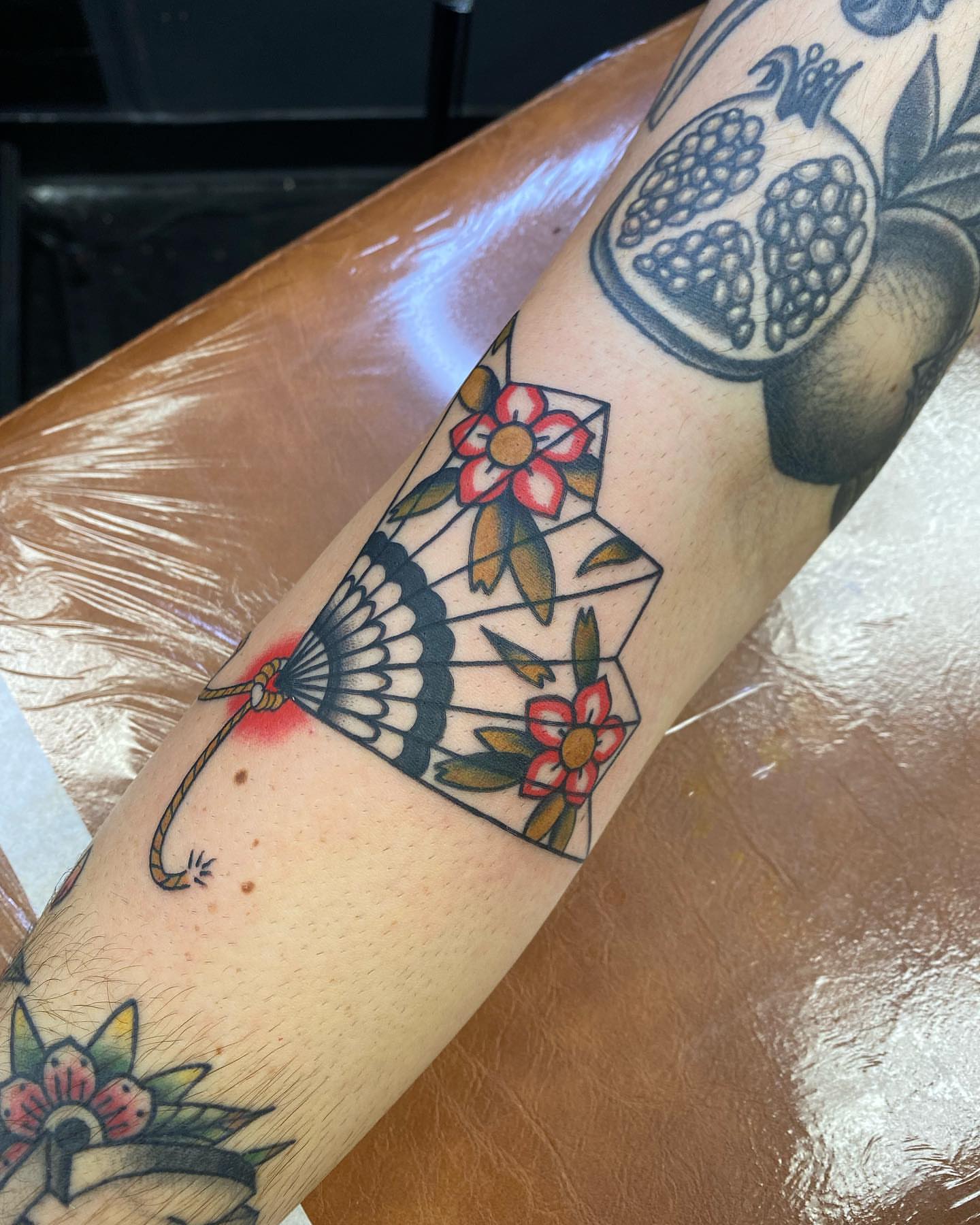 Fan and flowers American traditional tattoo on the forearm by S C O T T