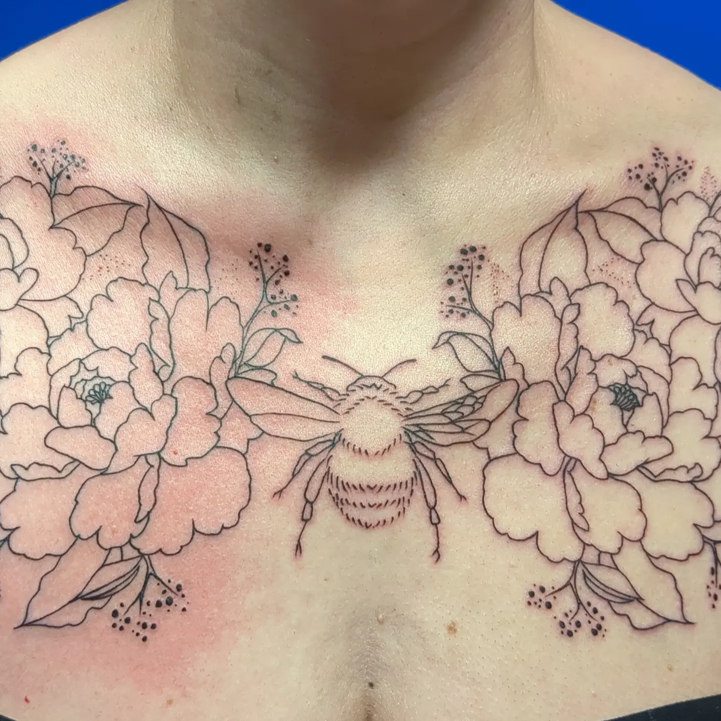 Bee and flowers black and grey tattoo on the chest by Kara Falcon