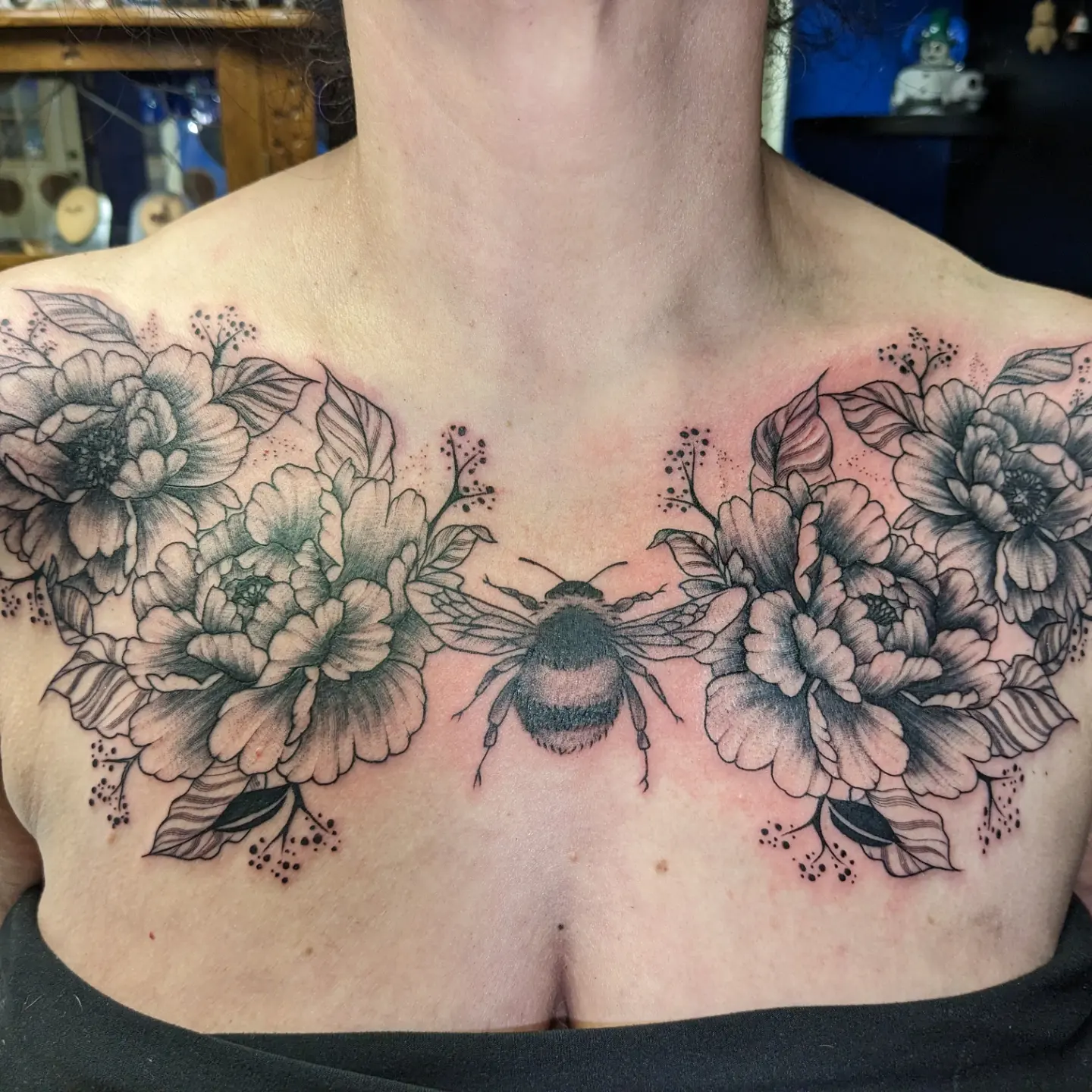 Bees and flowers black and grey tattoo on the chest by Kara Falcon