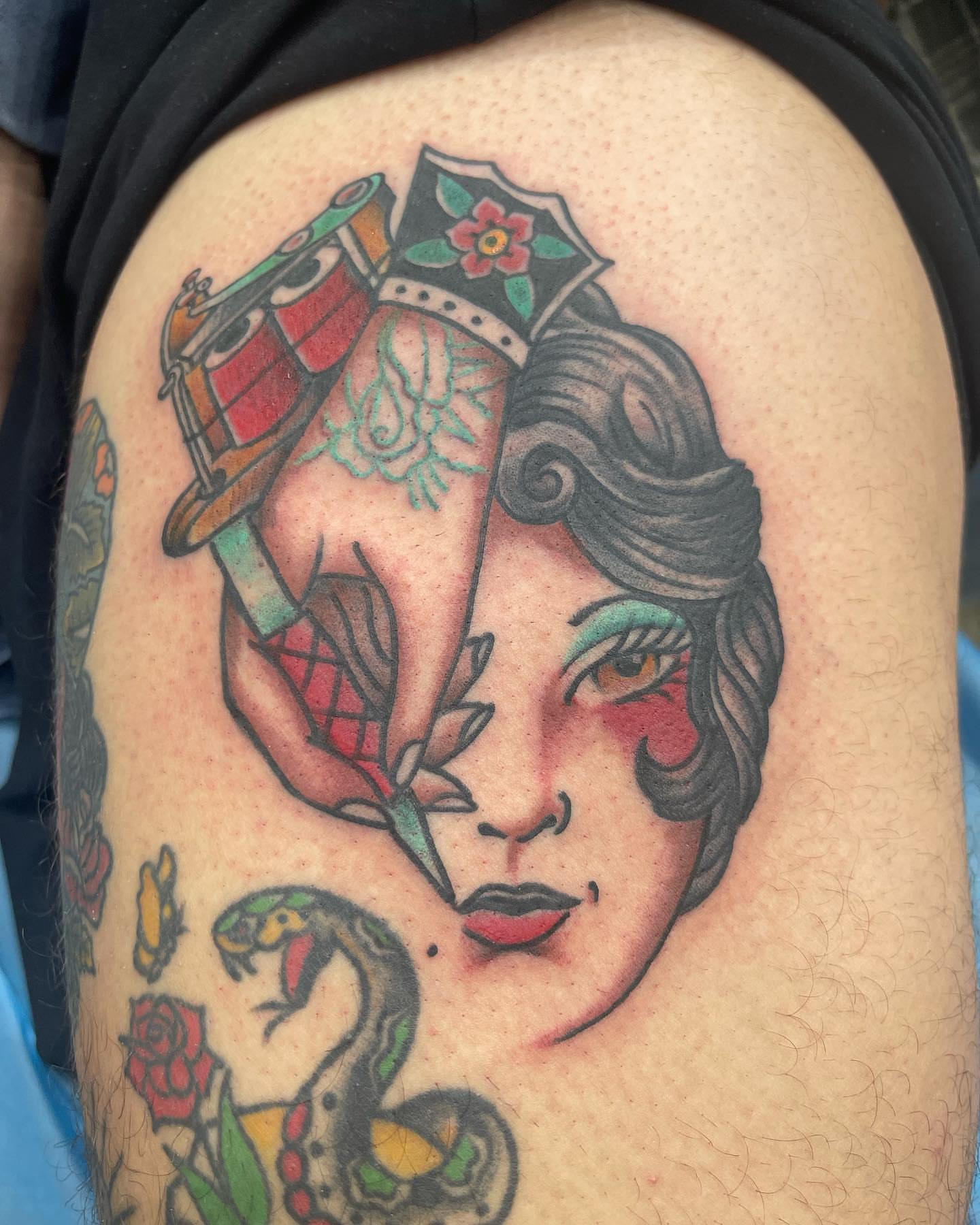 Woman's face with musical instruments American traditional tattoo on the thigh by Edward Choat
